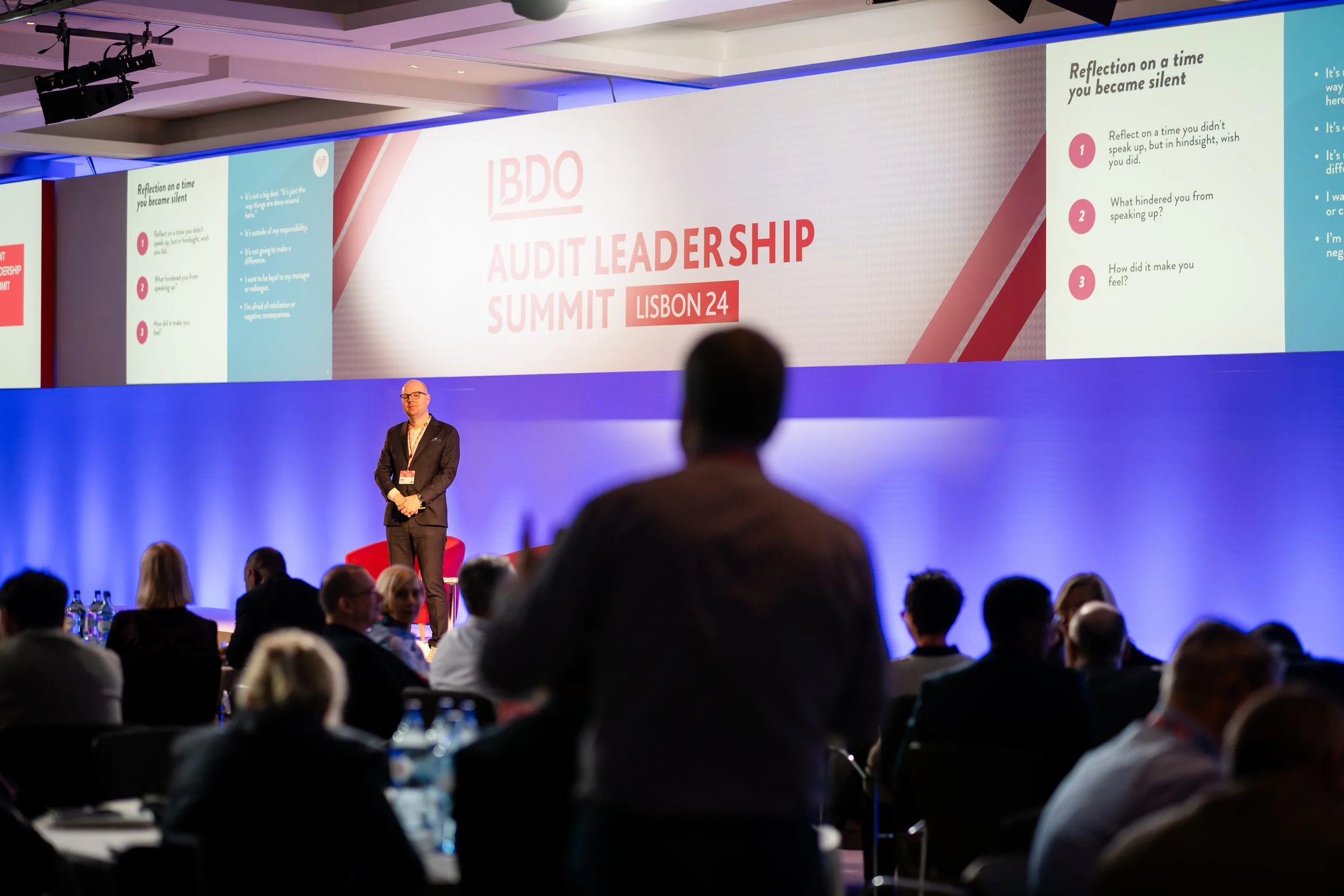Tobias Sturesson speaking at the BDO Audit Leadership Summit in Lisbon. Audience members are seated facing the stage, and one person is standing.