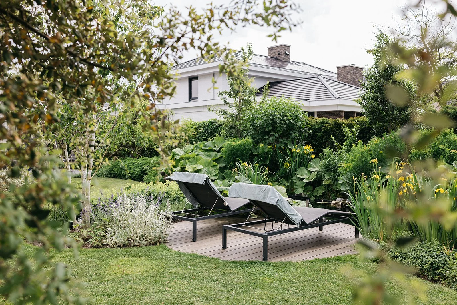 Vloeiende cottage garden met zwemvijver