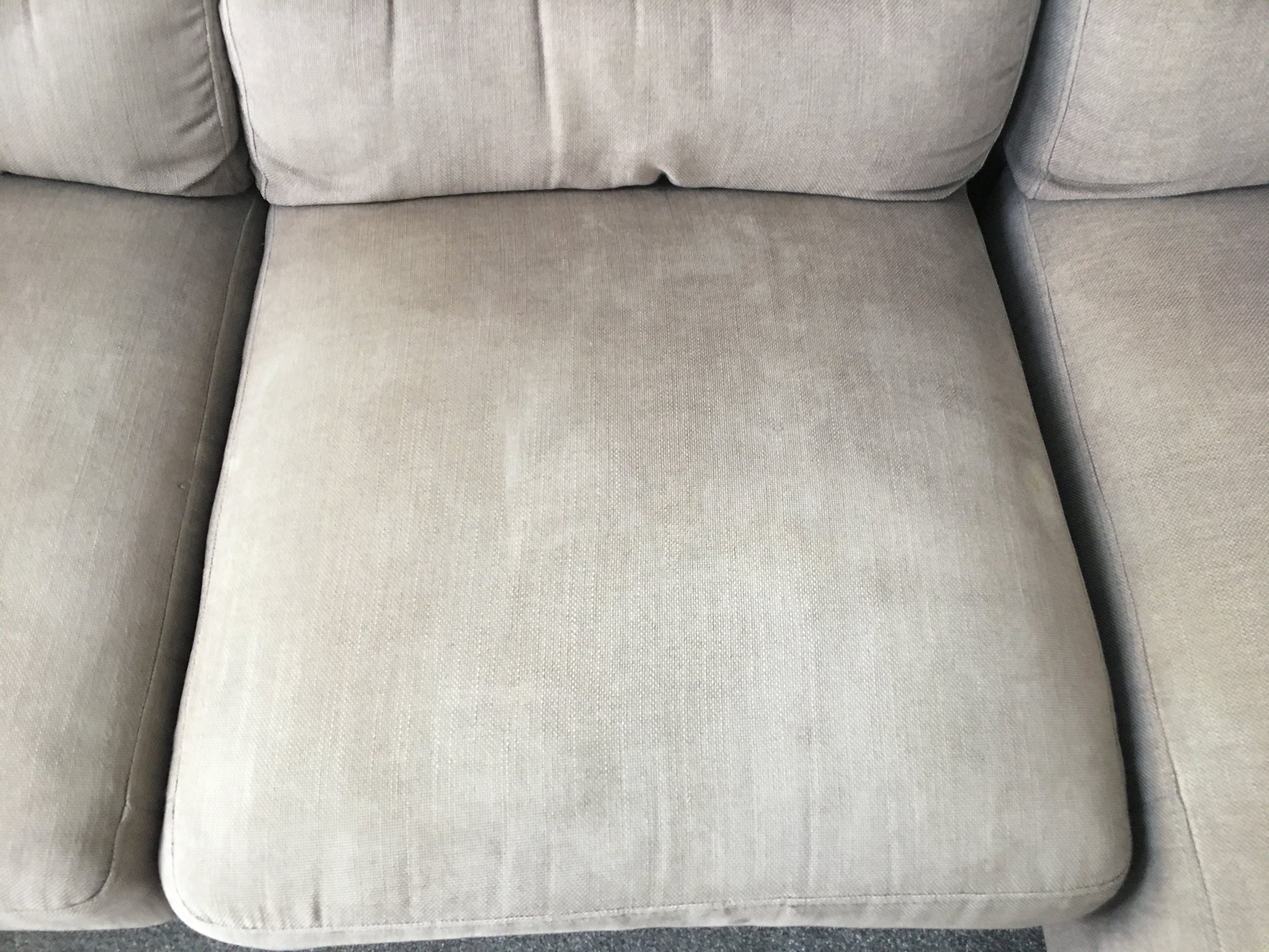 Light gray fabric sofa with plush cushions and rounded armrests.