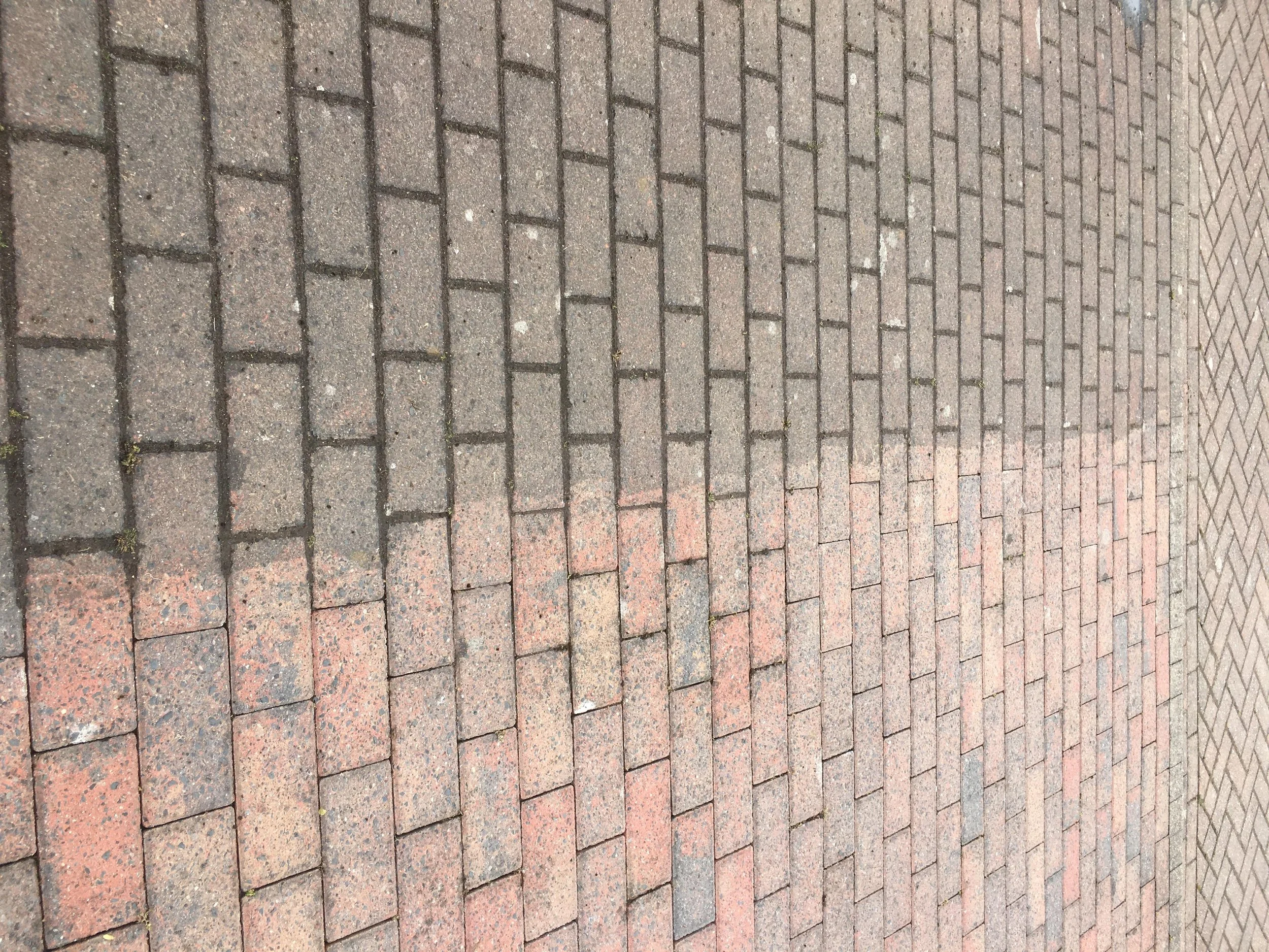 Close-up view of two types of brick pavement, one with darker reddish bricks and the other with lighter reddish bricks, arranged in a rectangular pattern.