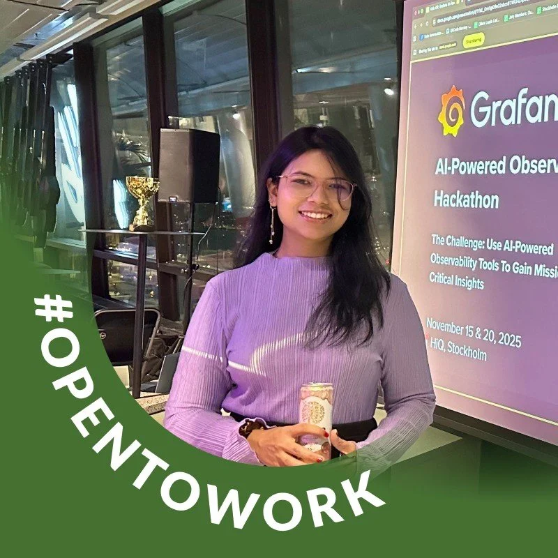 A young woman with long dark hair and glasses, smiling and holding a drink, standing in front of a large screen displaying a Grafana AI-powered observability hackathon presentation at HiQ in Stockholm, with a trophy on a stand in the background. The image has a green semicircle overlay with the hashtag #OPENWORK.