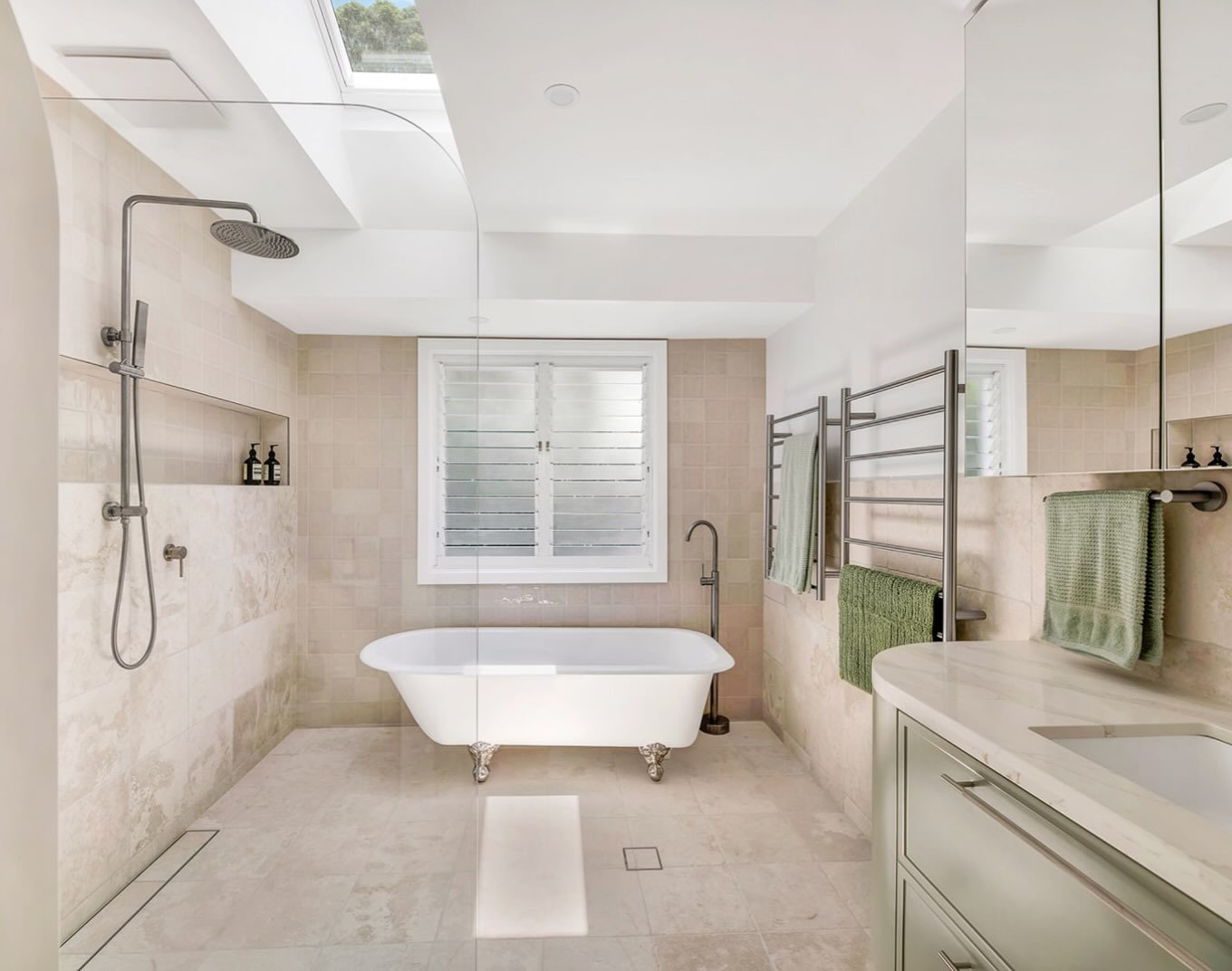 Natural light takes centre stage in this bathroom, with skylights and mounted windows creating bright, airy space. 

A recessed shower niche keeps the design clean and uncluttered while the freestanding bath and floor tap create a beautiful focal poi