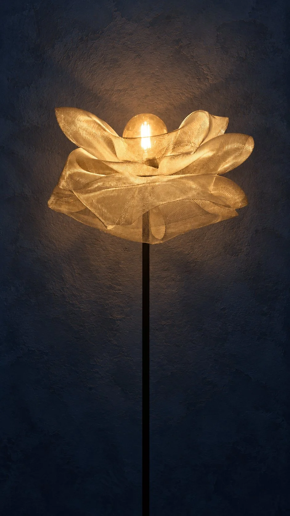 Lampe design artisanale en métal brut argenté avec ampoule à lumière jaune. Modèle Lully sur pied, studio Cajoa.