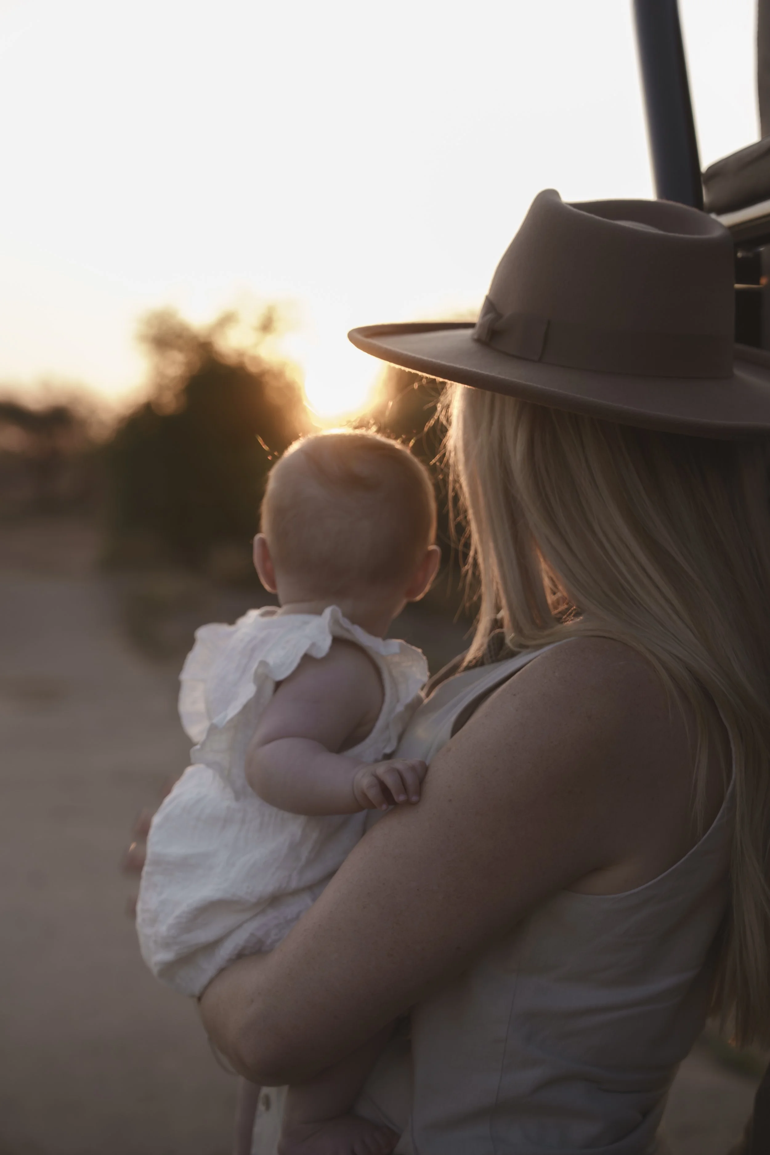Mother holding her baby at sunset in the African bush