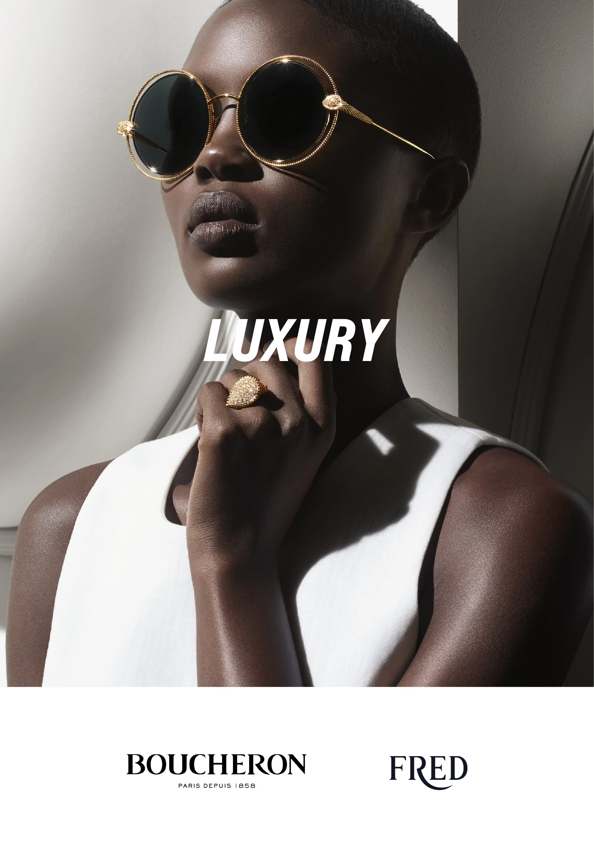 Close-up of a woman wearing large, round black sunglasses with gold details, including a ring and chain, and a white sleeveless top. The image features the word 'LUXURY' and the Boucheron and Fred brands