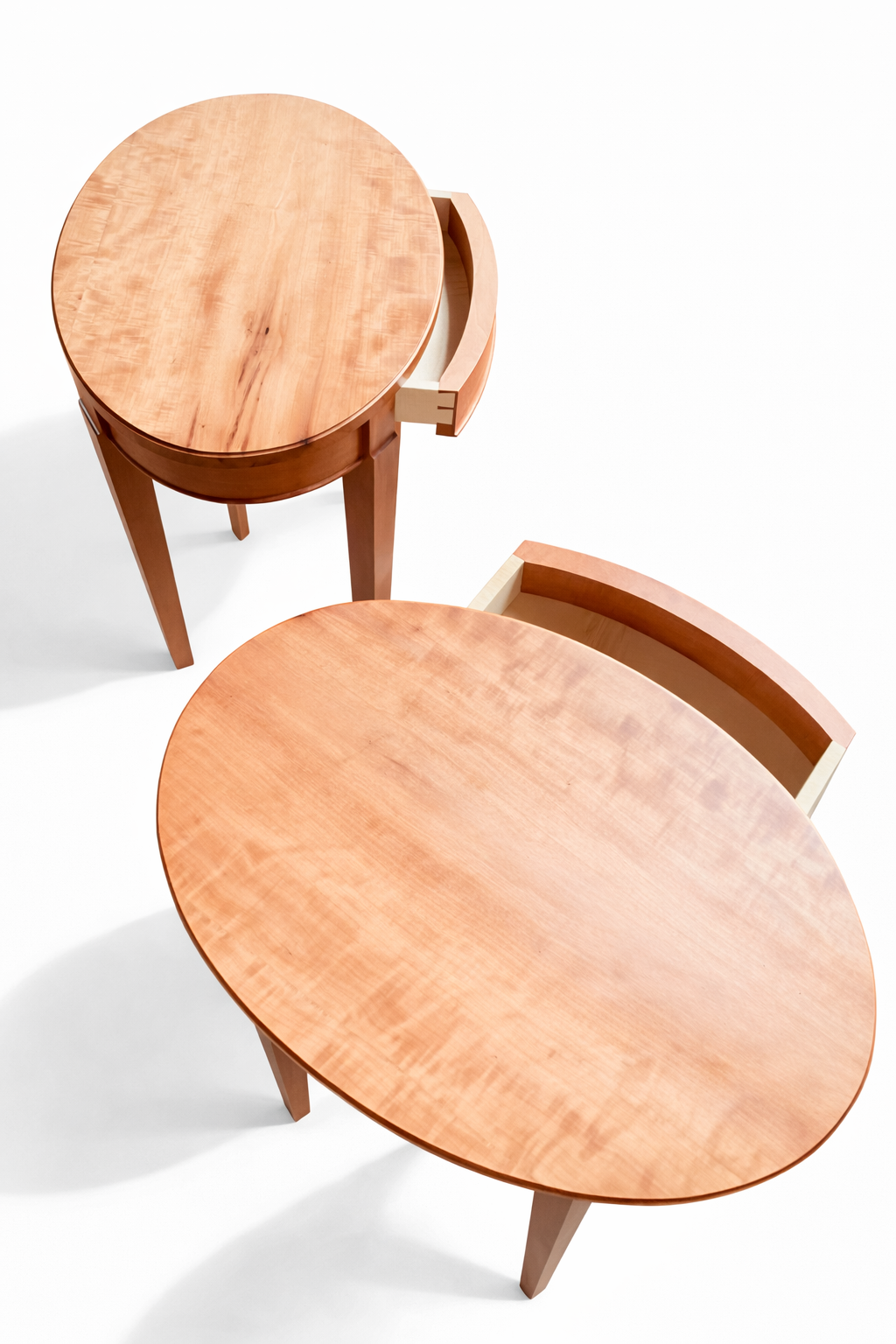 Two wooden tables with open drawers against a white background.