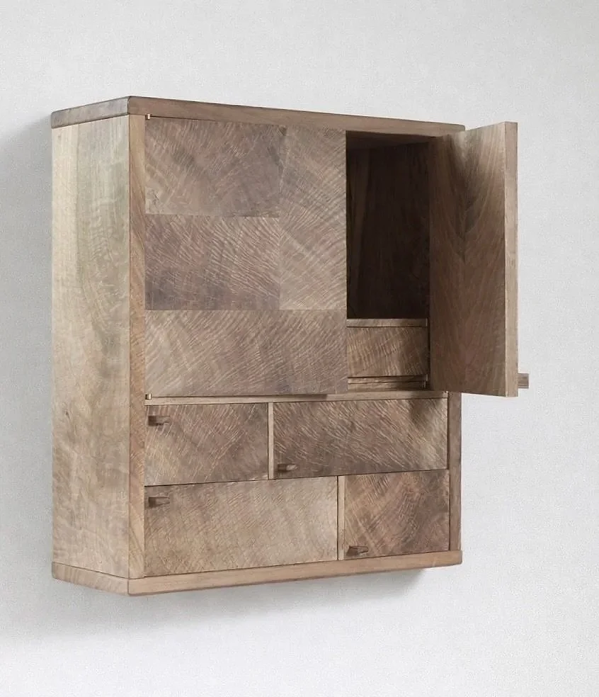 A wooden cabinet mounted on a white wall with multiple drawers and an open door, all made from light-colored wood.