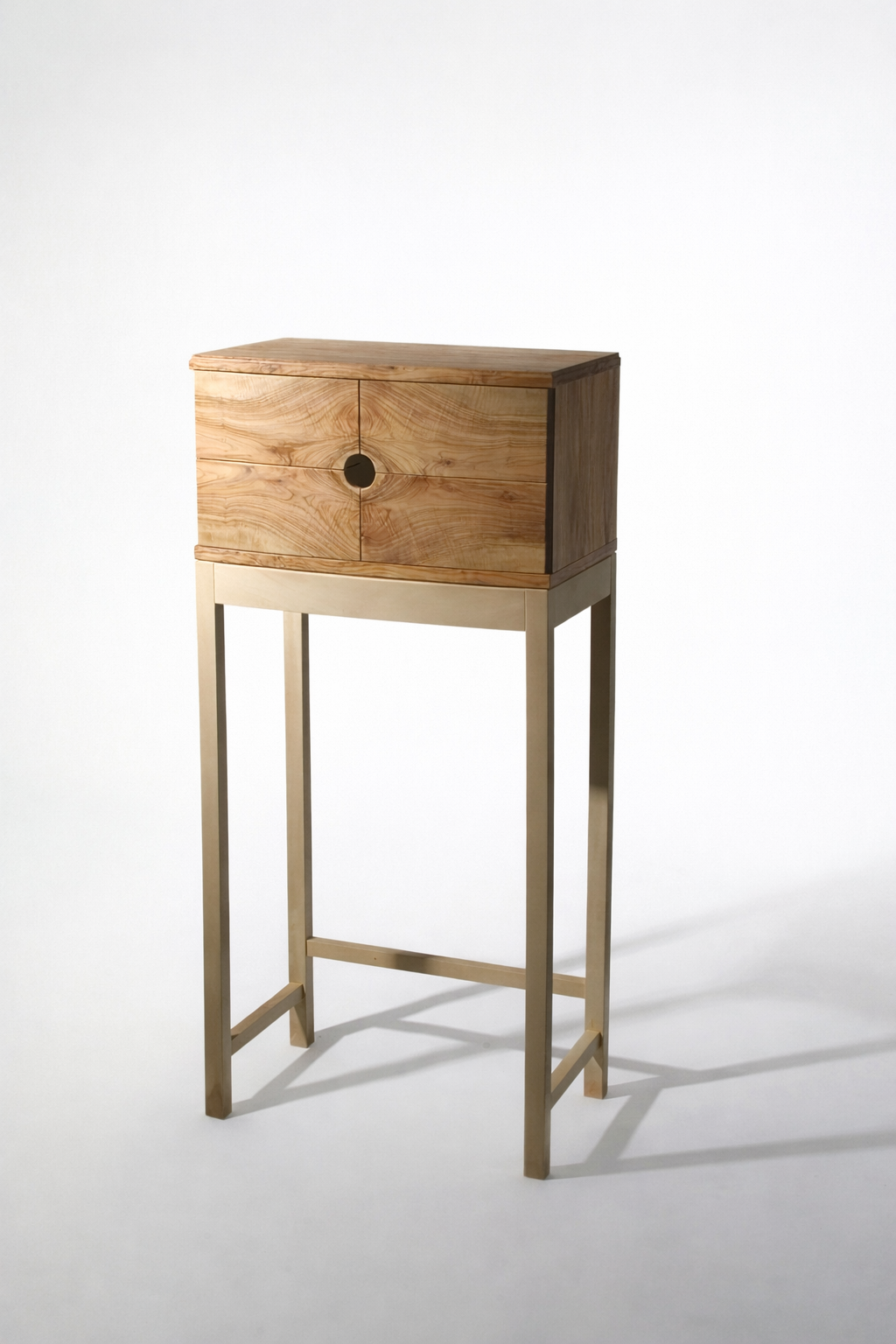 Wooden cabinet with a circular opening on the front, placed on a tall stand, against a plain white background.