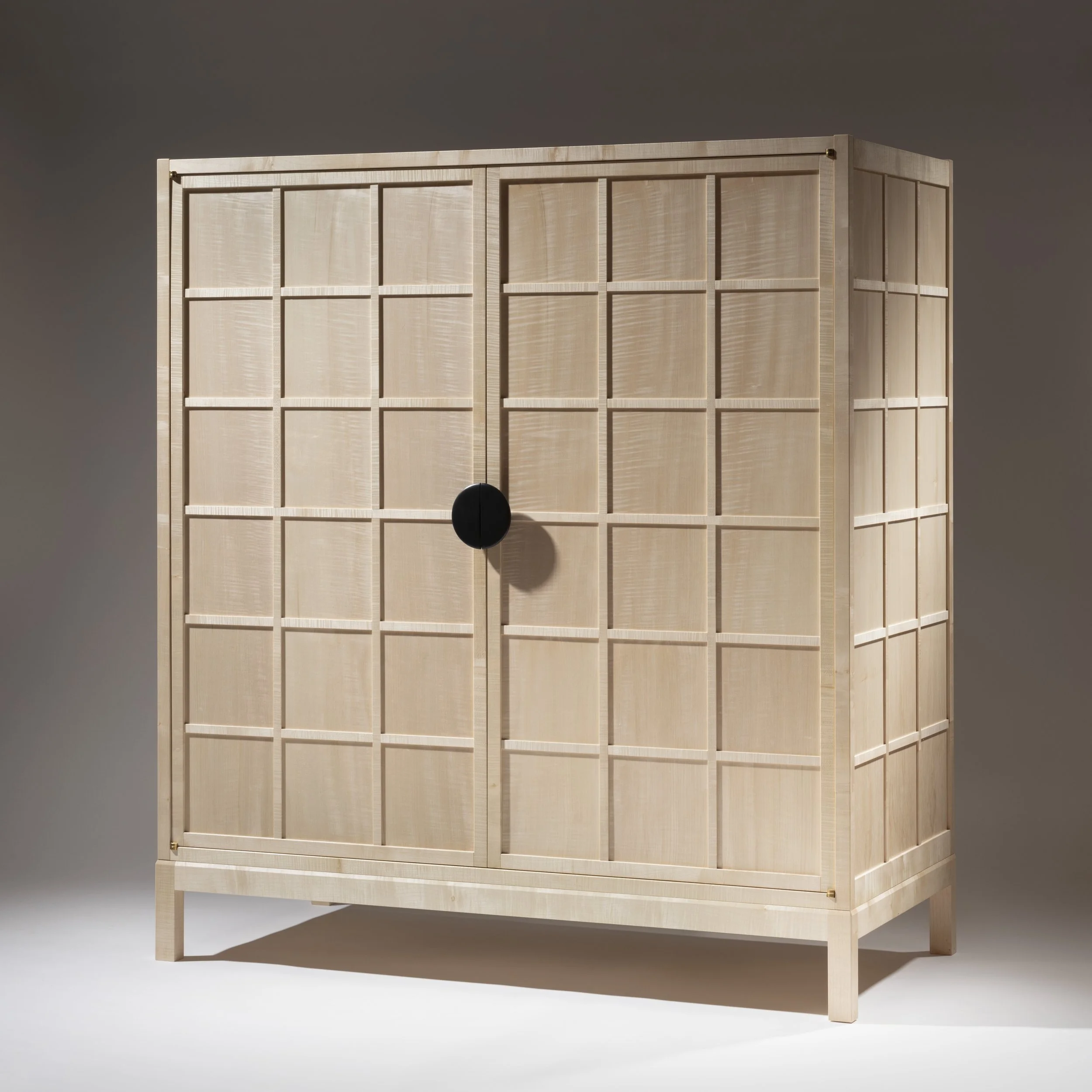 A light wooden grid-patterned wardrobe with two doors and a round black handle in the middle, standing on four legs against a plain background.