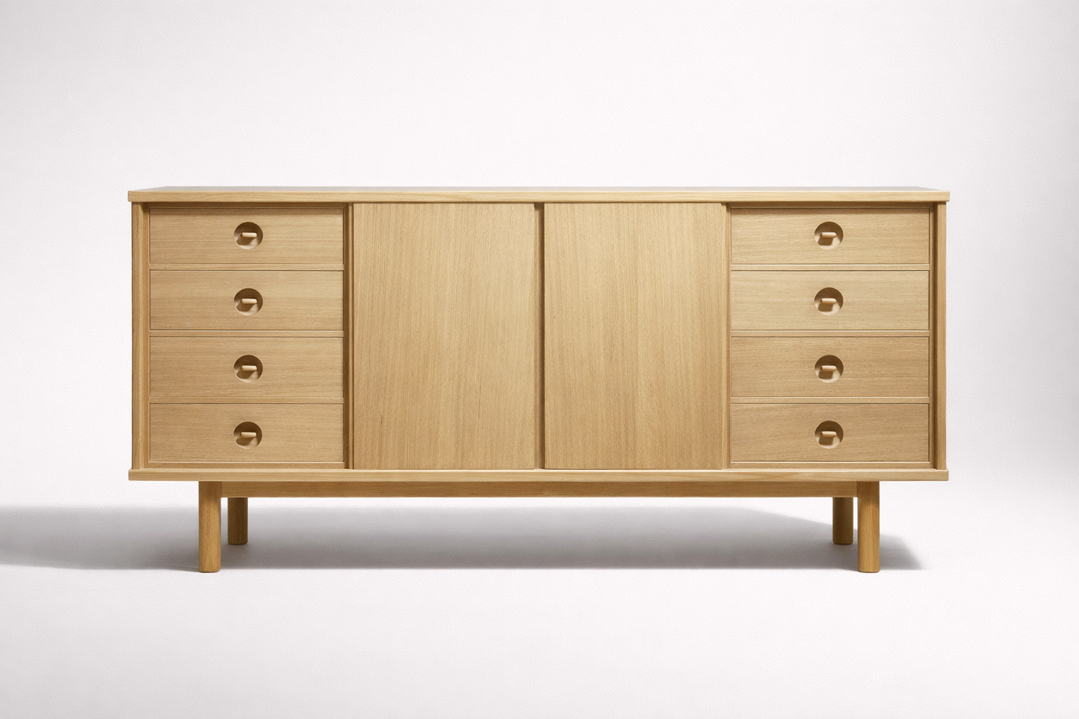 A minimalist wooden sideboard with six drawers and two sliding doors, standing on four legs against a plain white background.