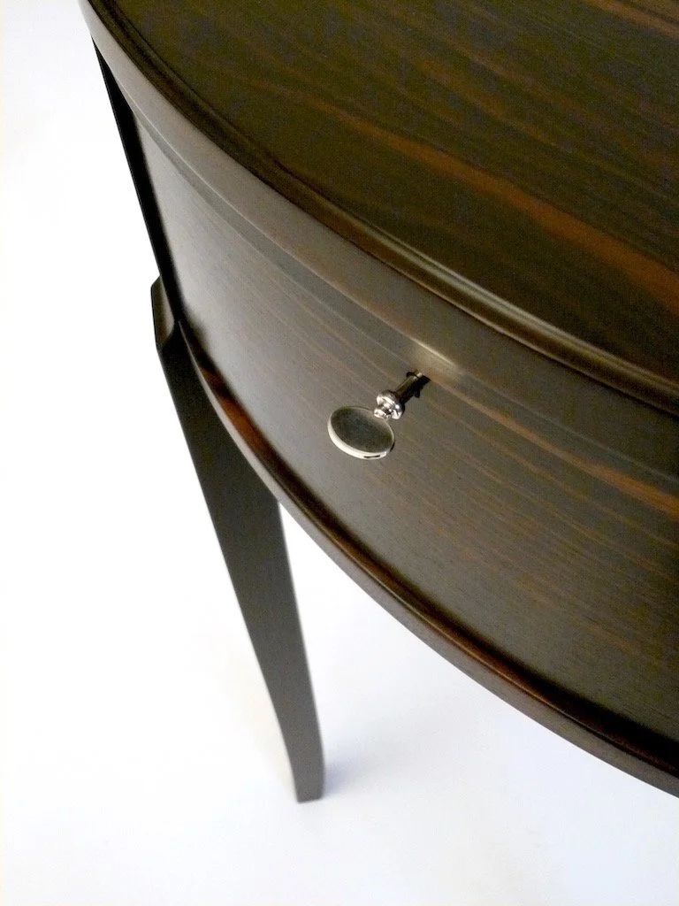 Close-up of a wooden drawer with a shiny metal handle