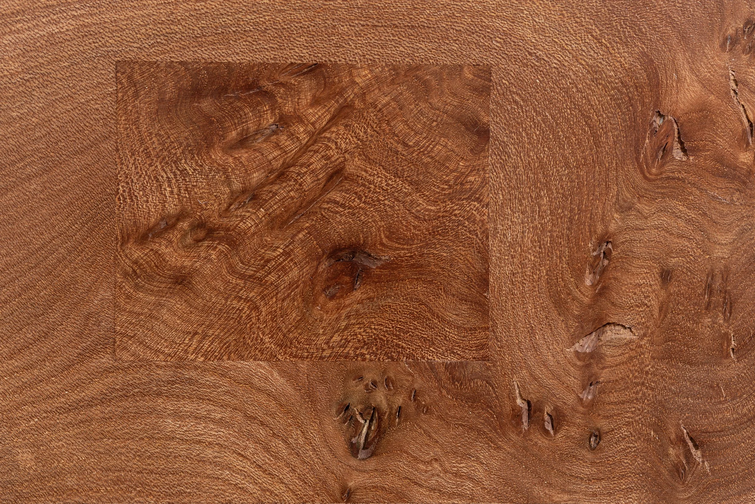 Close-up of a wooden surface showing detailed grain patterns and knots.