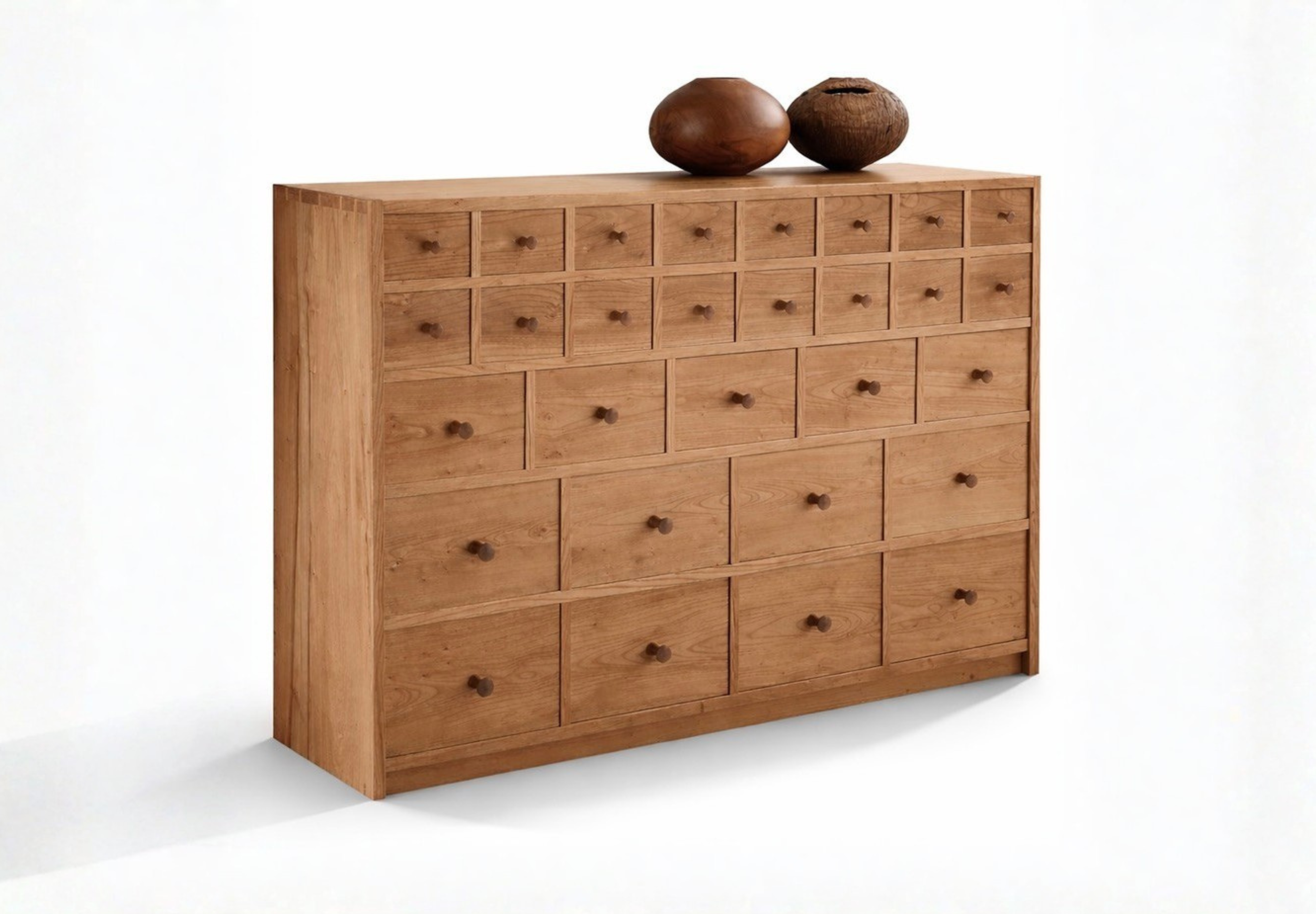 A wooden dresser with multiple small drawers topped with three wooden vases of different shapes and sizes.