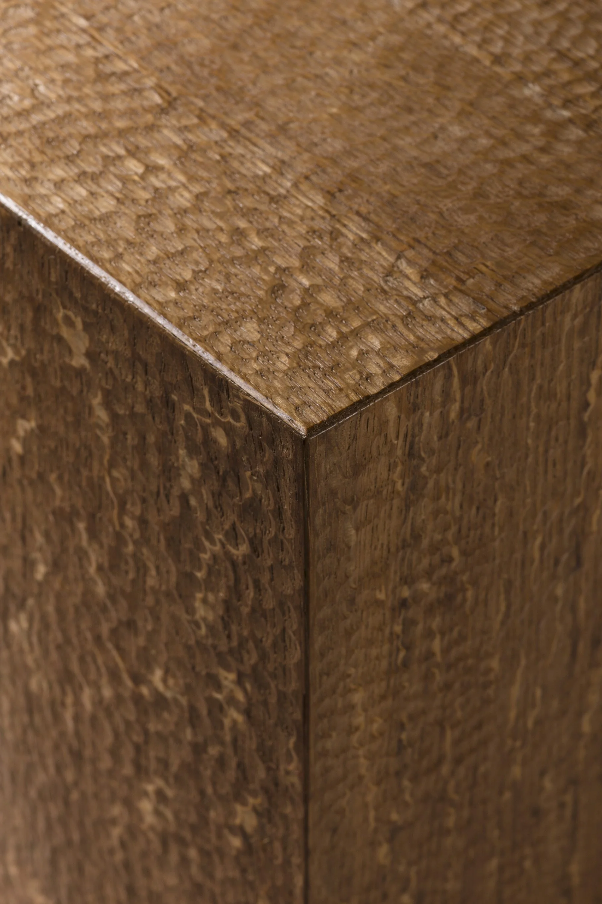 Close-up photo of a wooden corner showing textured wood grain and finish.