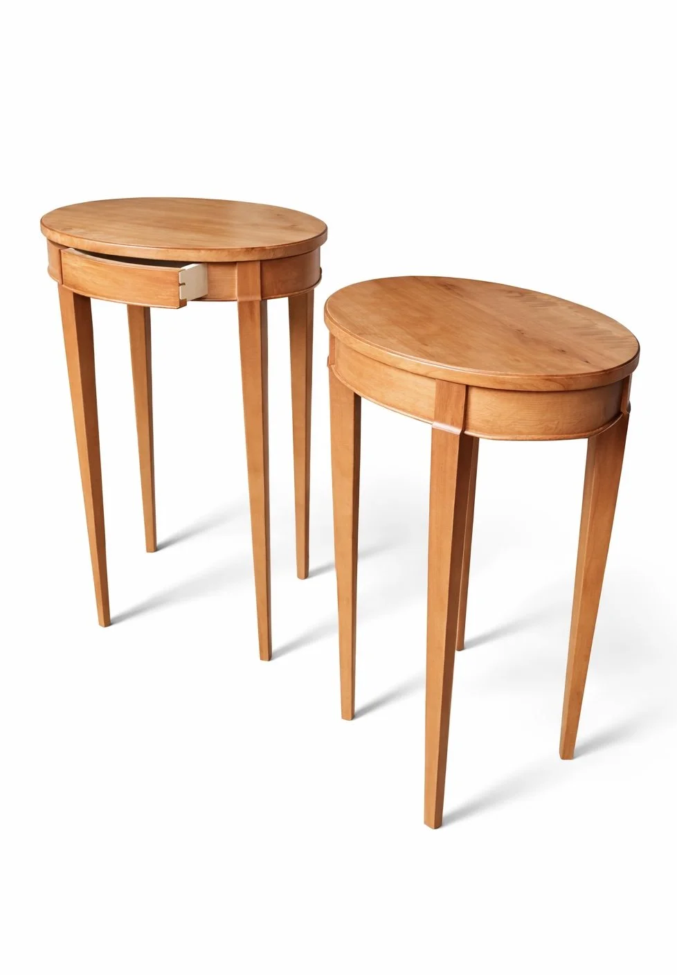 Two wooden side tables with rounded tops and four tapered legs each.