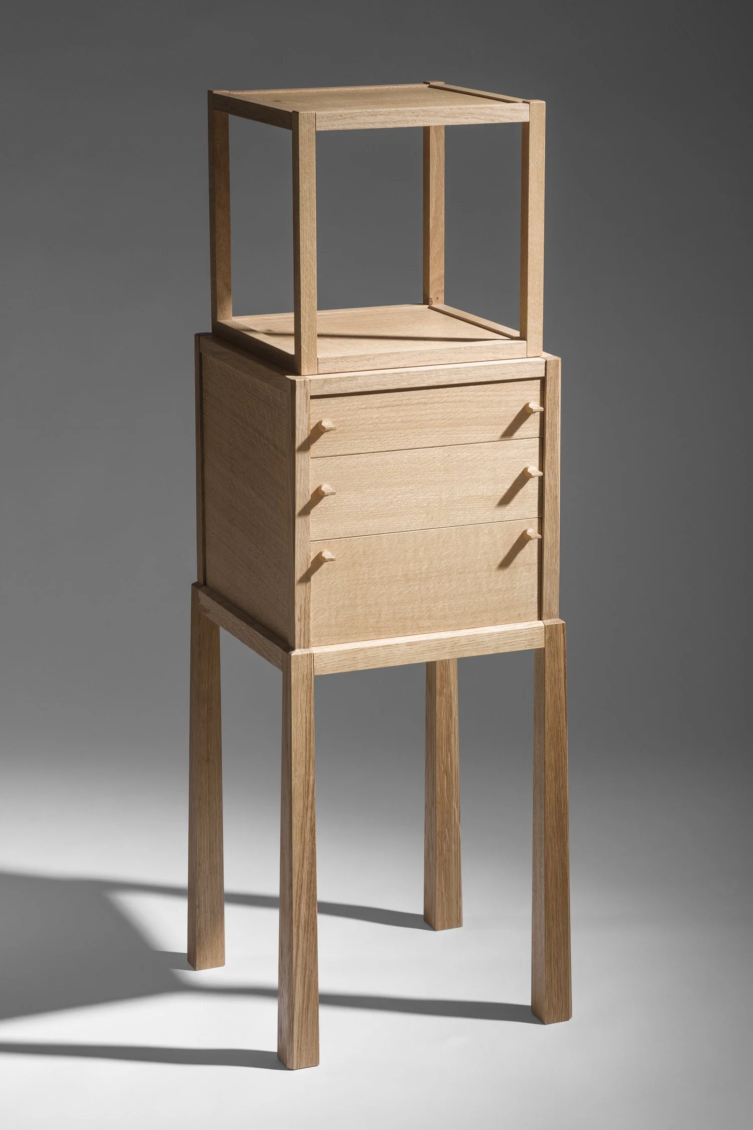 A wooden cabinet with open frames and multiple drawers, against a neutral background.