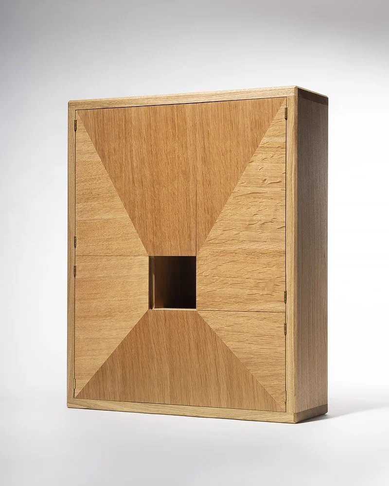 A wooden cabinet with four panels and a small square opening in the center.