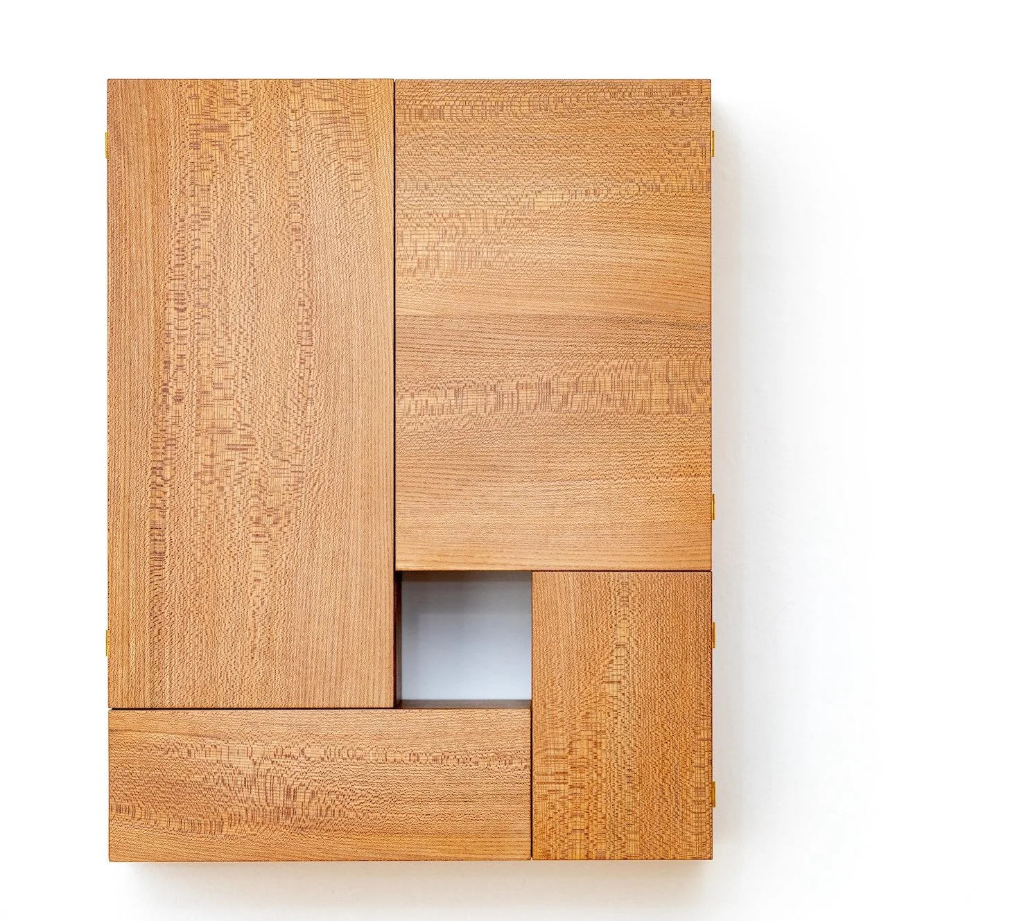 A wooden wall-mounted cabinet with multiple rectangular doors and a small open square compartment in the center, made of light-colored wood.