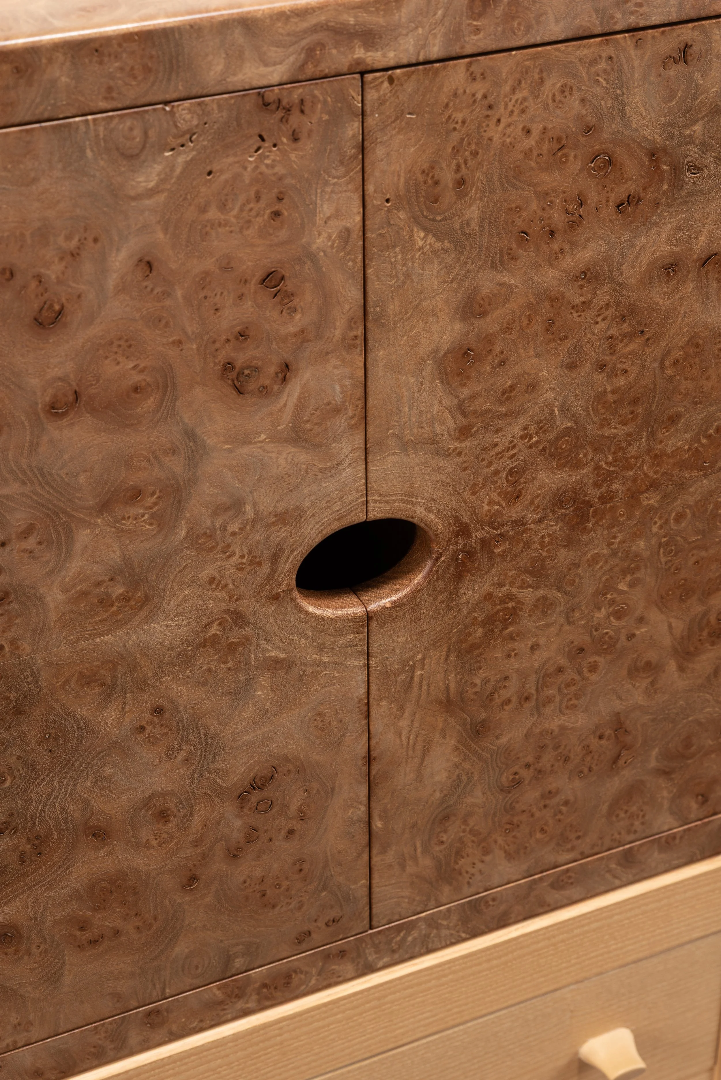Close-up of a wooden cabinet with a round hole in the center of the door.