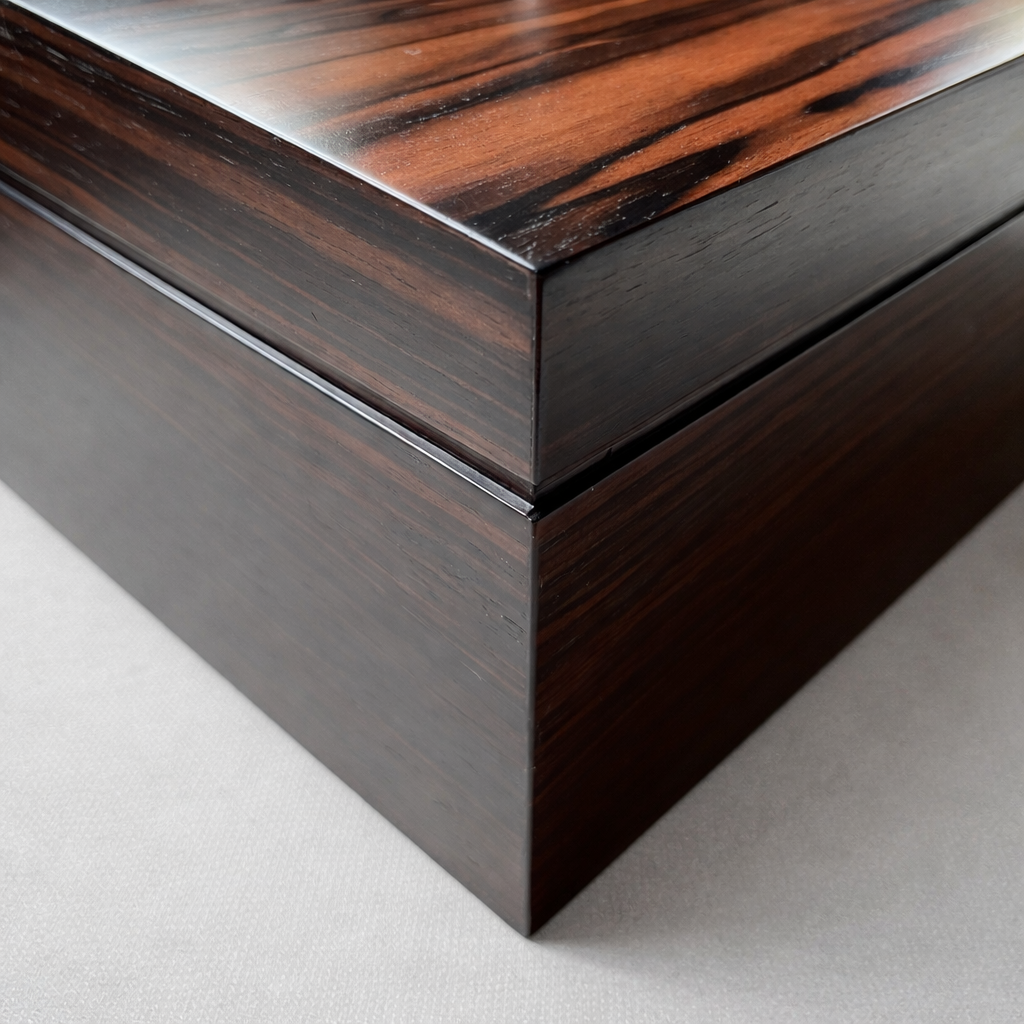 Close-up view of the corner of a dark wooden box with a glossy finish.