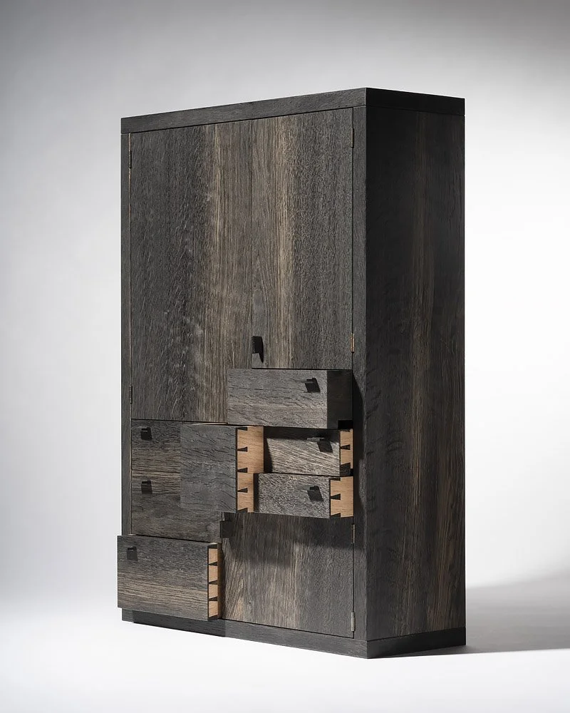 A tall, dark wooden cabinet with multiple drawers and compartments, some of which are partially open.