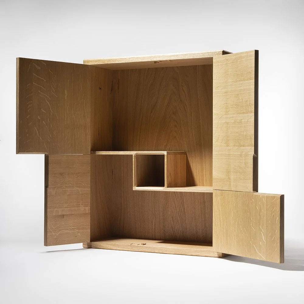 A wooden cabinet with open doors, showing multiple compartments and a minimalist design.