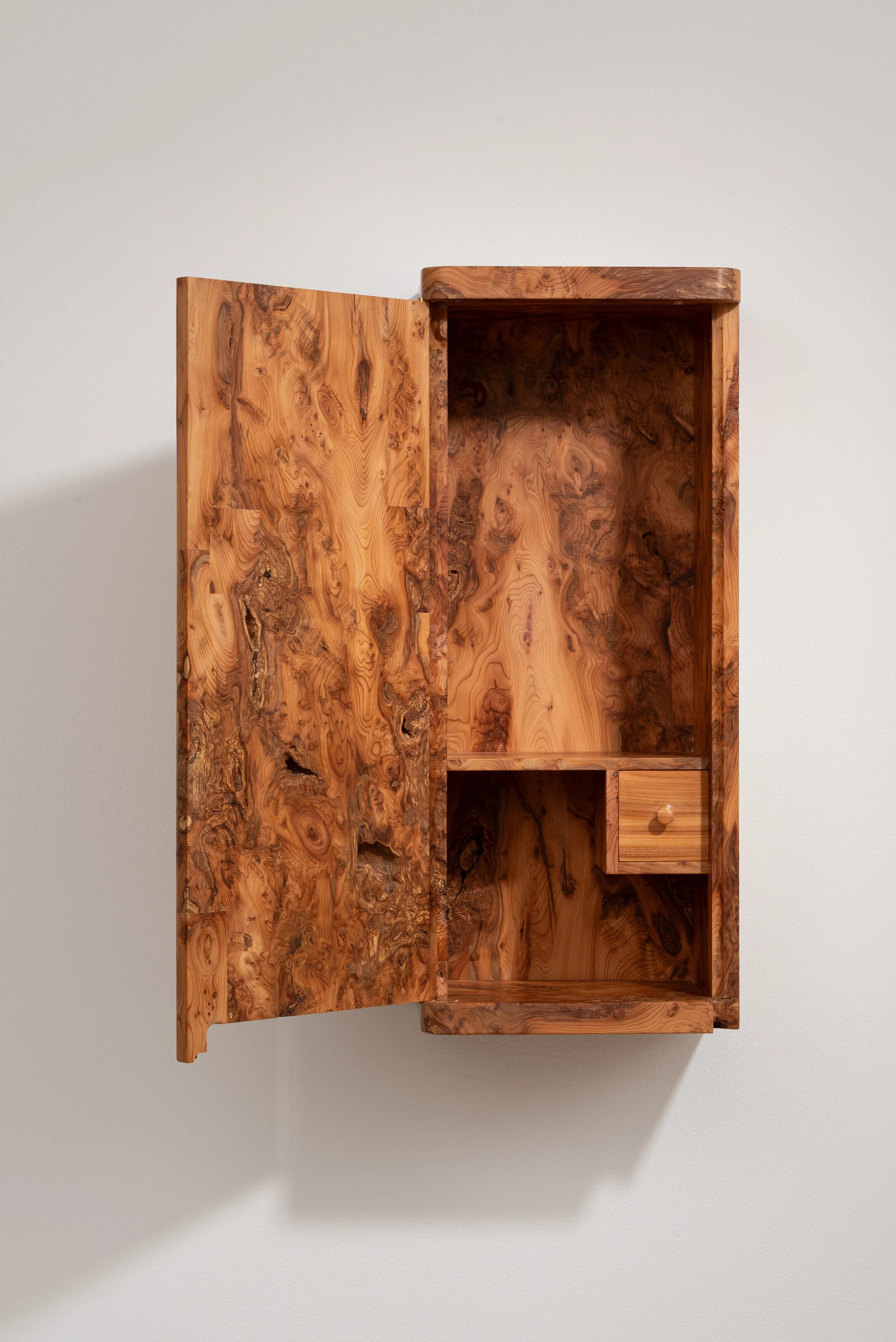 Open wooden wall cabinet with two shelves, one small drawer, and natural wood grain patterns.
