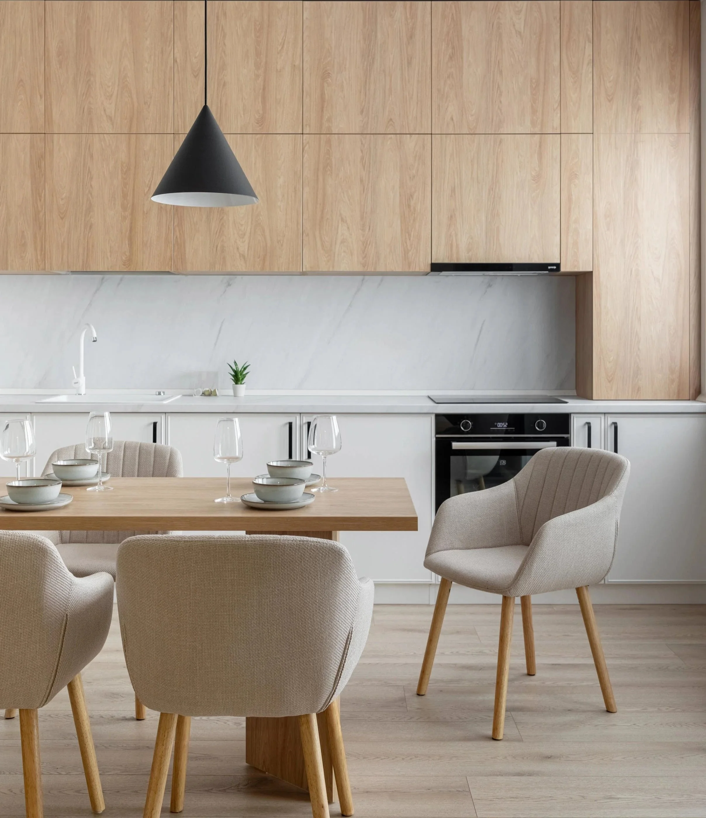 Bucatarie si  de luat masa parte dintr-un proeict de design interior modern, lemn, marmura, alb, nuante de bej, accente metalice negre, spatiu luminos