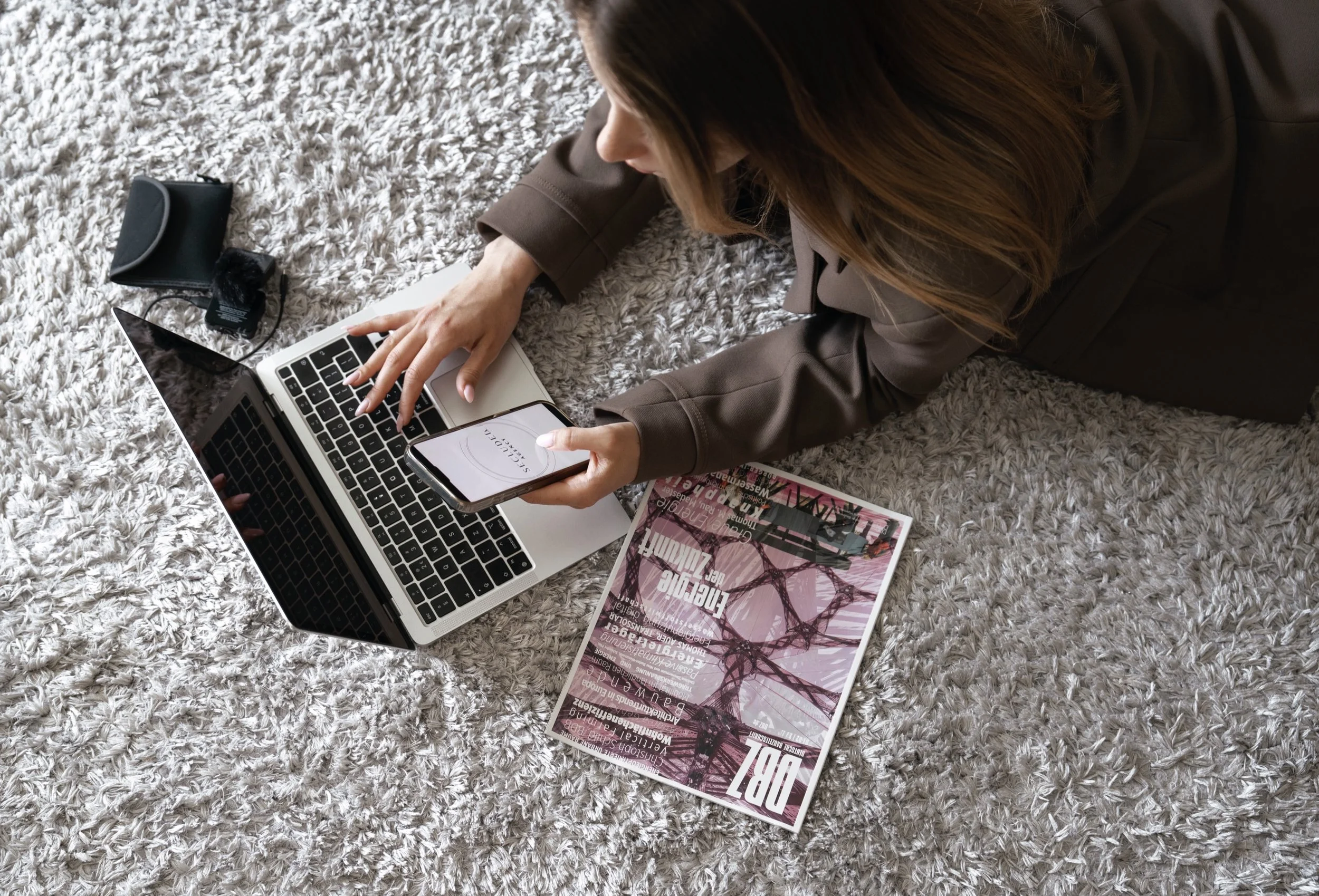 Refined social media strategy and content creation for beauty and lifestyle brands at Secluded Agency showcasing a laptop and smartphone, with a magazine and content equipment.