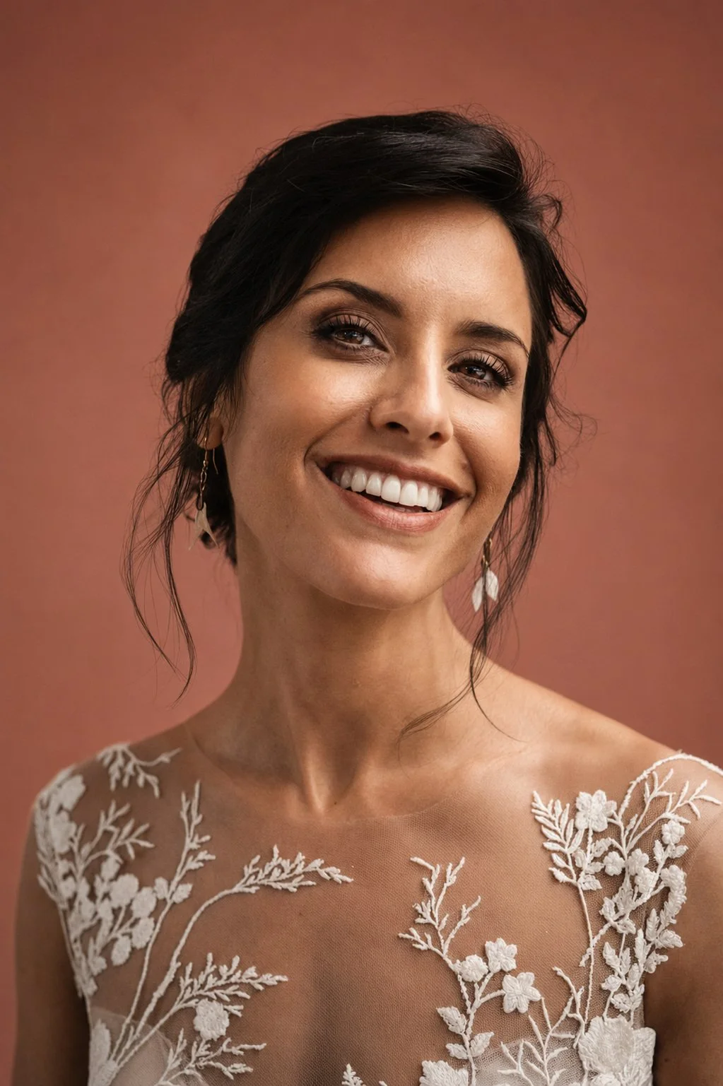 Porträt einer lächelnden Braut in einem Kleid mit floraler Spitze.