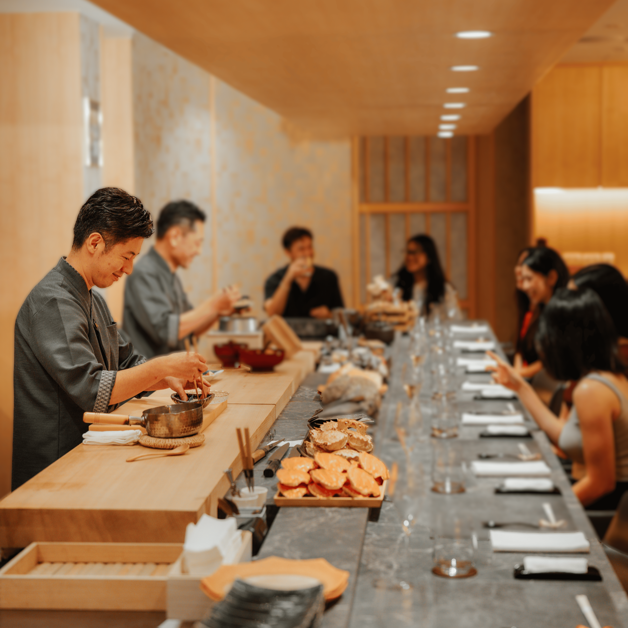 Chefs serving guests at the Jiin Omakase main dining counter.