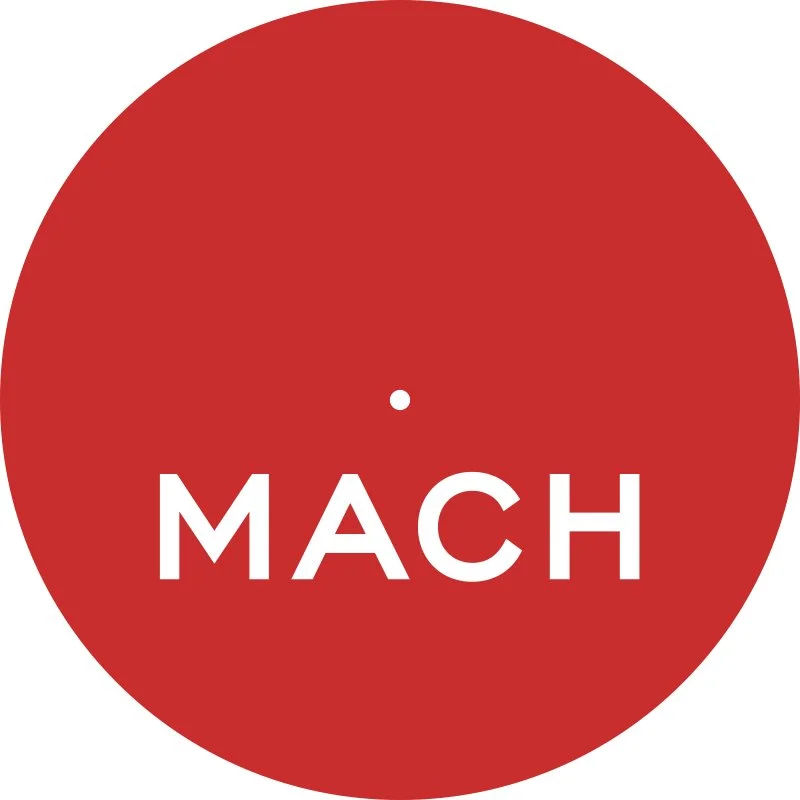 Red circular graphic resembling a tape measure with the word 'MACH' in white uppercase letters across the center.