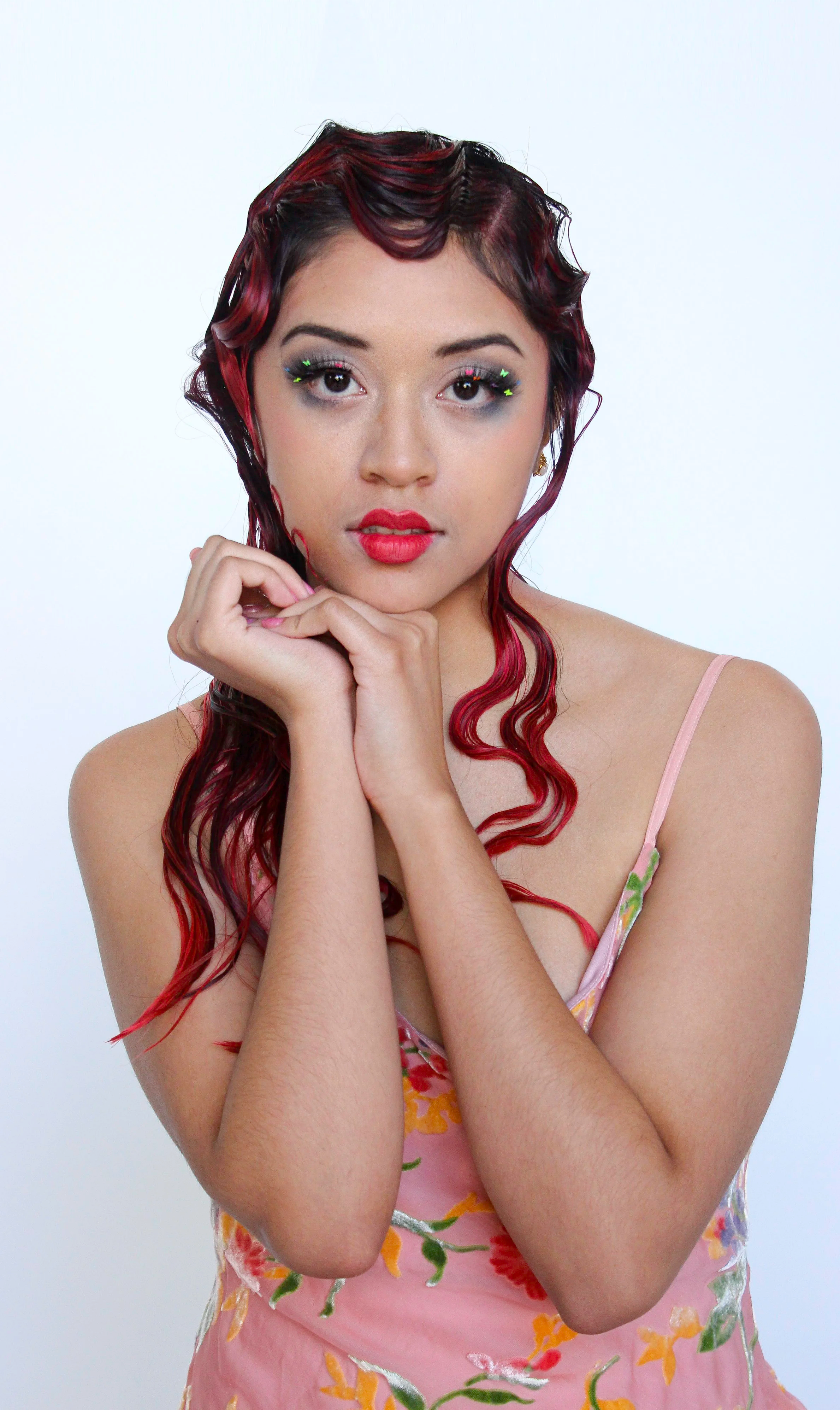 1920's style fingerwaves on long red hair, model with false lashes with colorful butterflies, heart shaped red lips, vintage neon dress