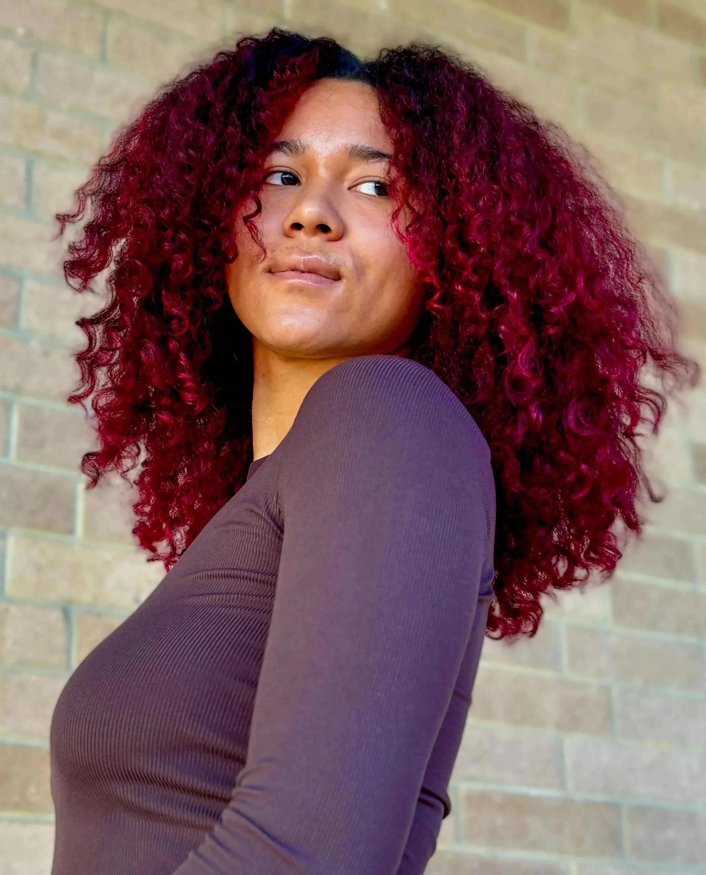 long curly hair dyed a bright red violet