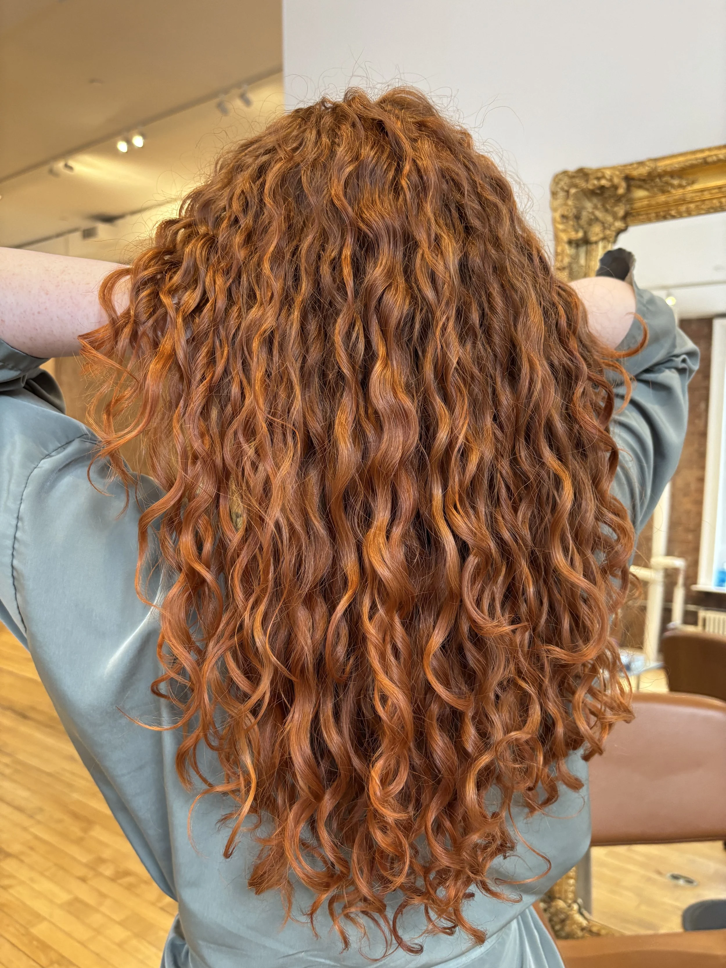 long curly copper hair with dimensional deeper brown reds