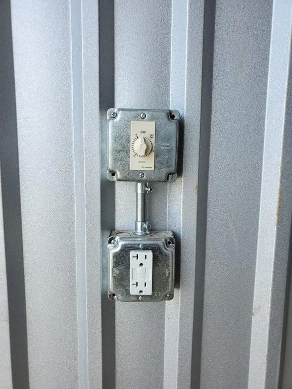 Electrical outlet and exposed switch on a metallic wall.