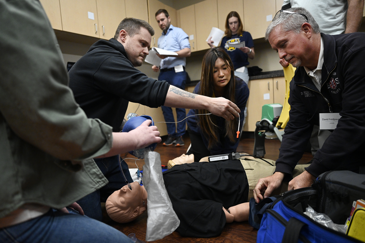 Workshop attendees fit an INSIGHT-CPR prototype onto a medical mannikin during a simulation of an out-of-hospital cardiac arrest.