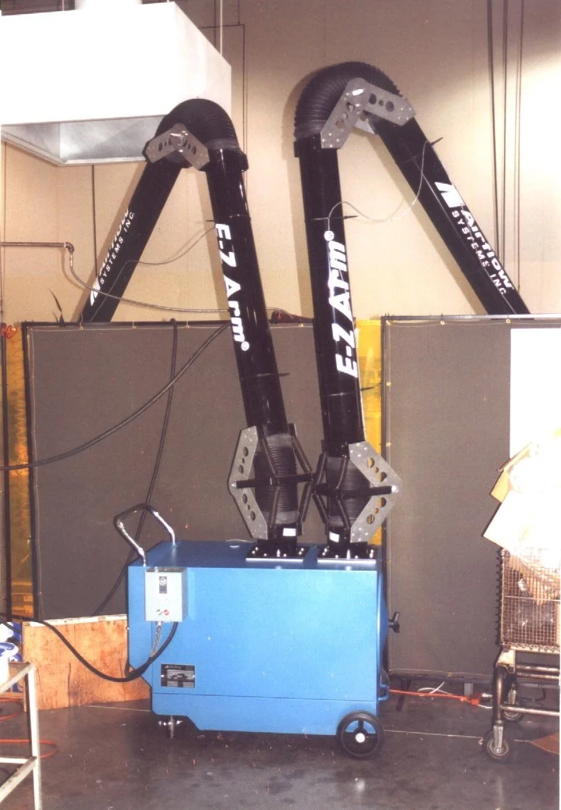 Industrial smoke extraction system with two large black arms labeled 'E-Z APPLIANCE' connected to a blue mobile unit.