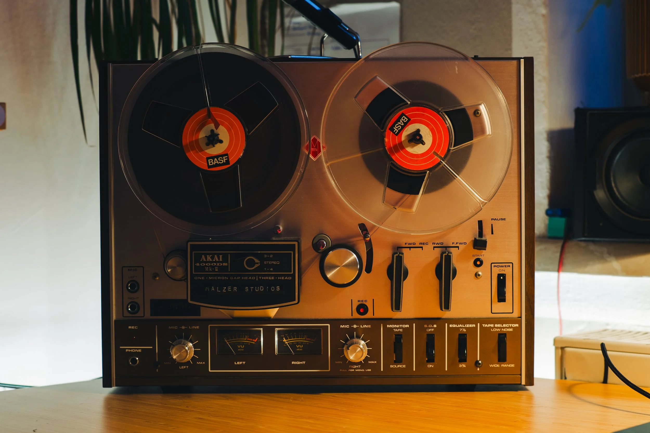 Vintage stereo turntable with two spinning vinyl records, wooden sides, and control knobs, placed on a table in a room.