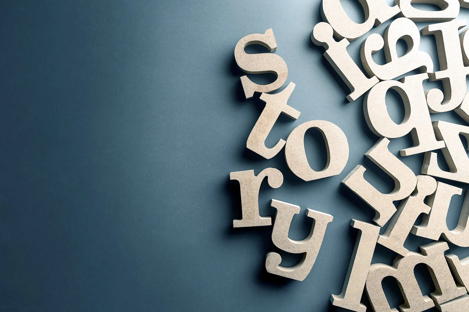 Scattered beige 3D wooden letters on a blue background, with the word 'story' prominently visible.