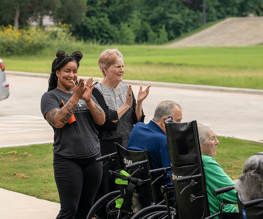 Bella Groves caregiver engaging with residents during an outdoor activity at our award-winning residential dementia care and memory care community in Bulverde, Texas.