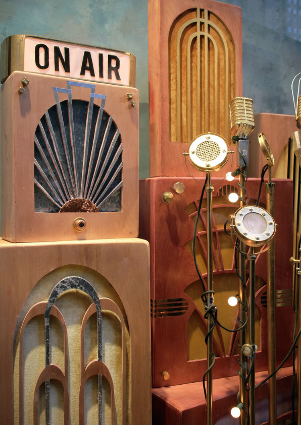 Various vintage radio-style microphones and speakers displayed in a retro setting. Retail window display by Breena Farrelly for Anthropologie.