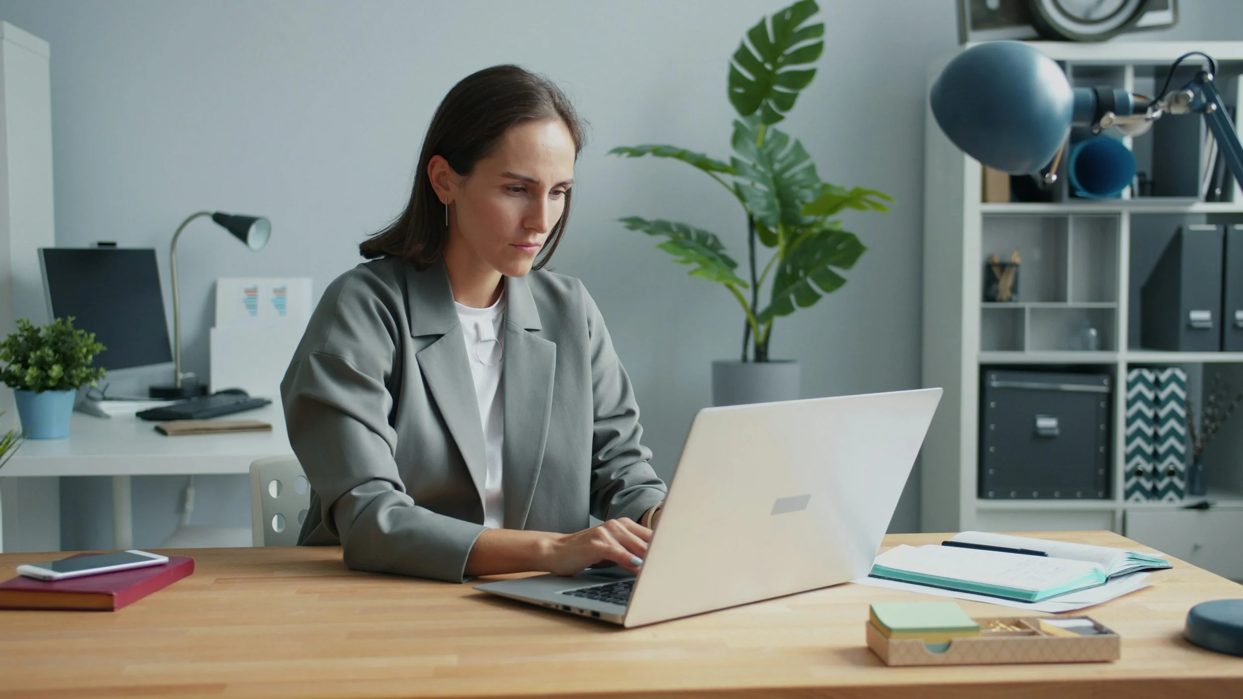 Professionnelle concentrée travaillant sur un ordinateur dans un espace de travail organisé