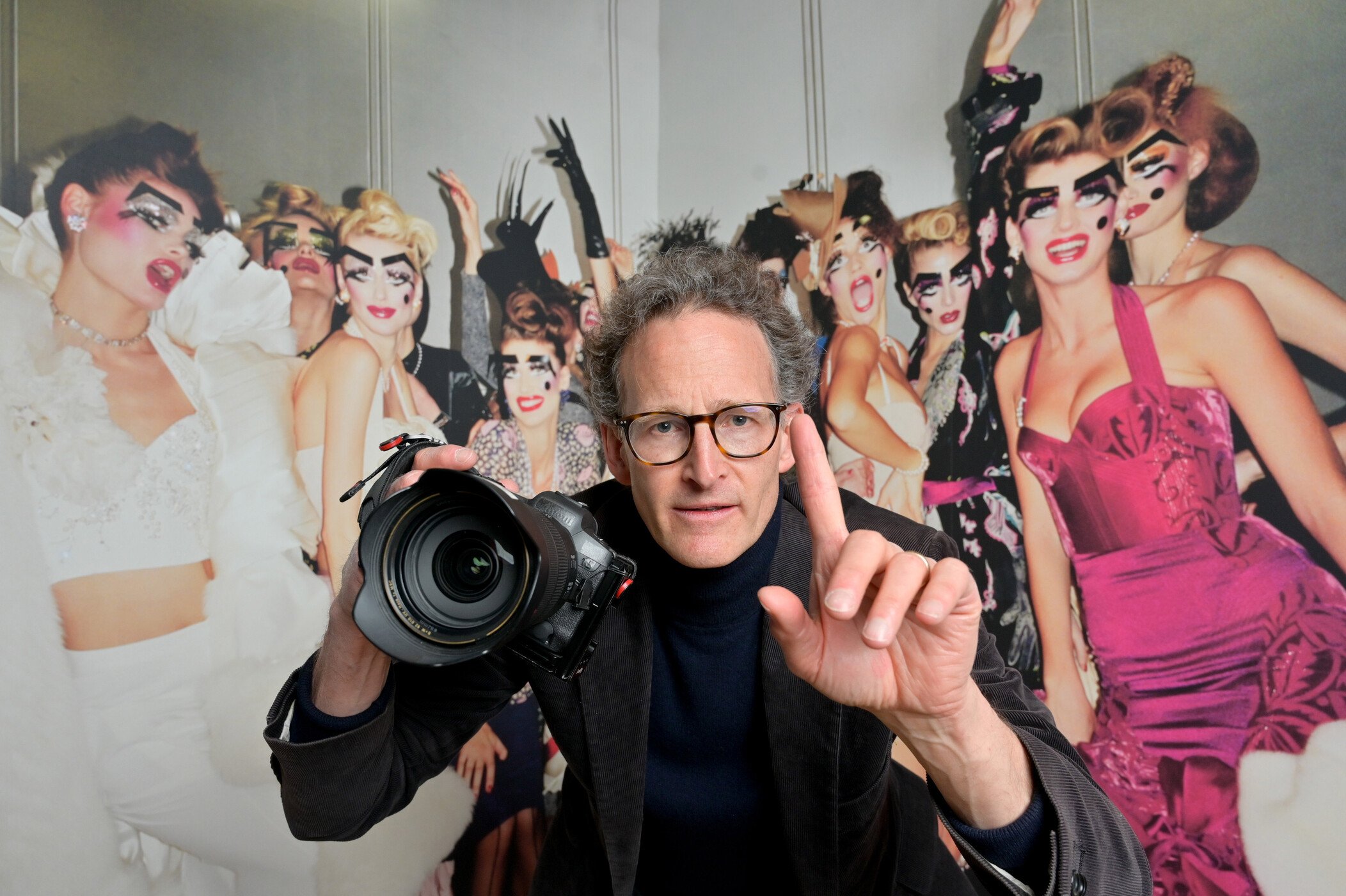   Fashion Photographer Robert Fairer in front of one of his photographs in Catwalk: The Art of the Fashion Show at V&amp;A Dundee. Image above by: Julie Howden for V&amp;A Dundee  
