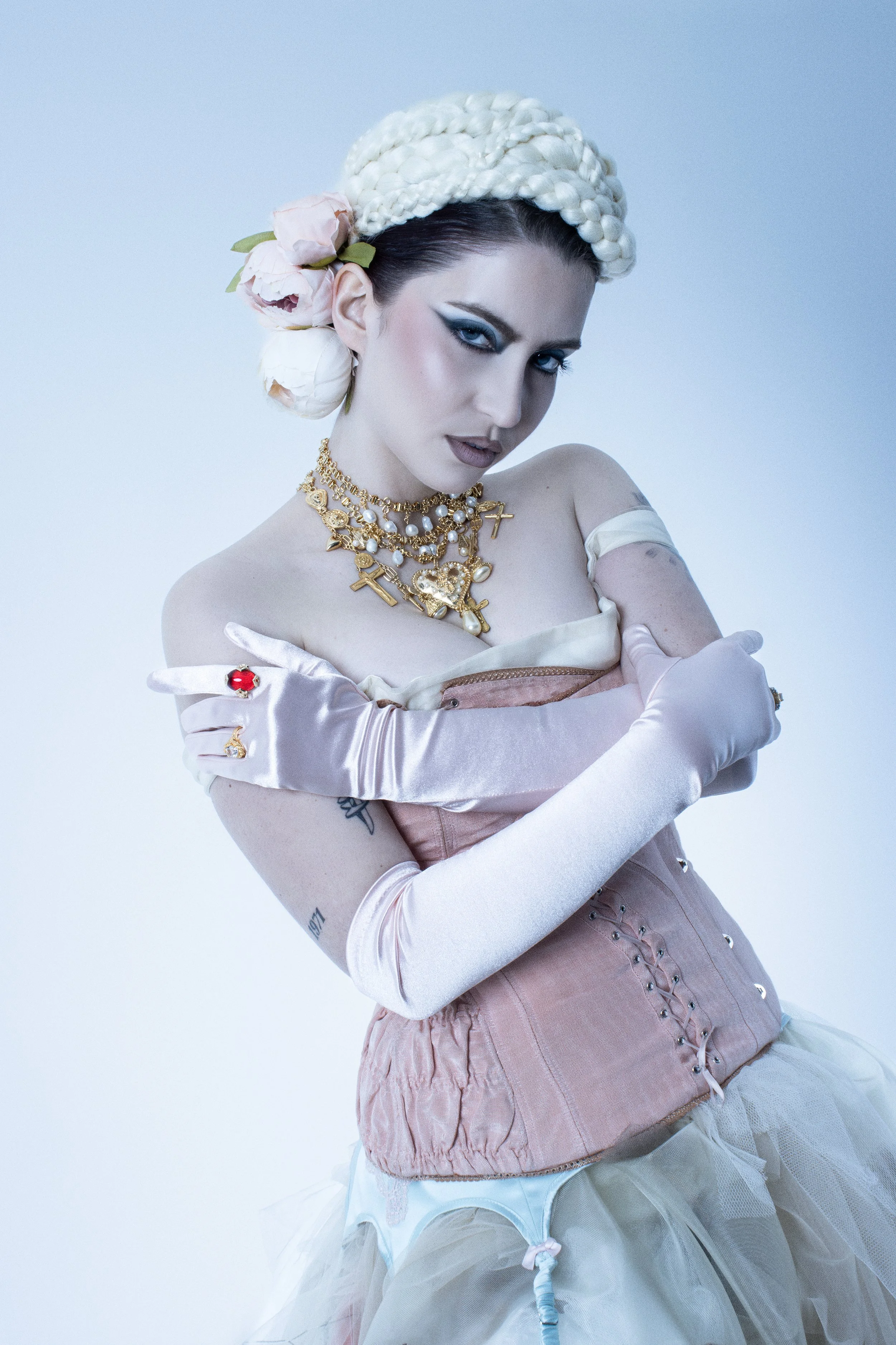   Abby Roberts wears, Dress: Layal Balubaid, Corset: Stravi, Garter Belt: Scarlett Gasque, Necklaces: Eras of Mystique &amp; Rebel Roses, Gloves: Dents, Hair Design: Laura Swaine  
