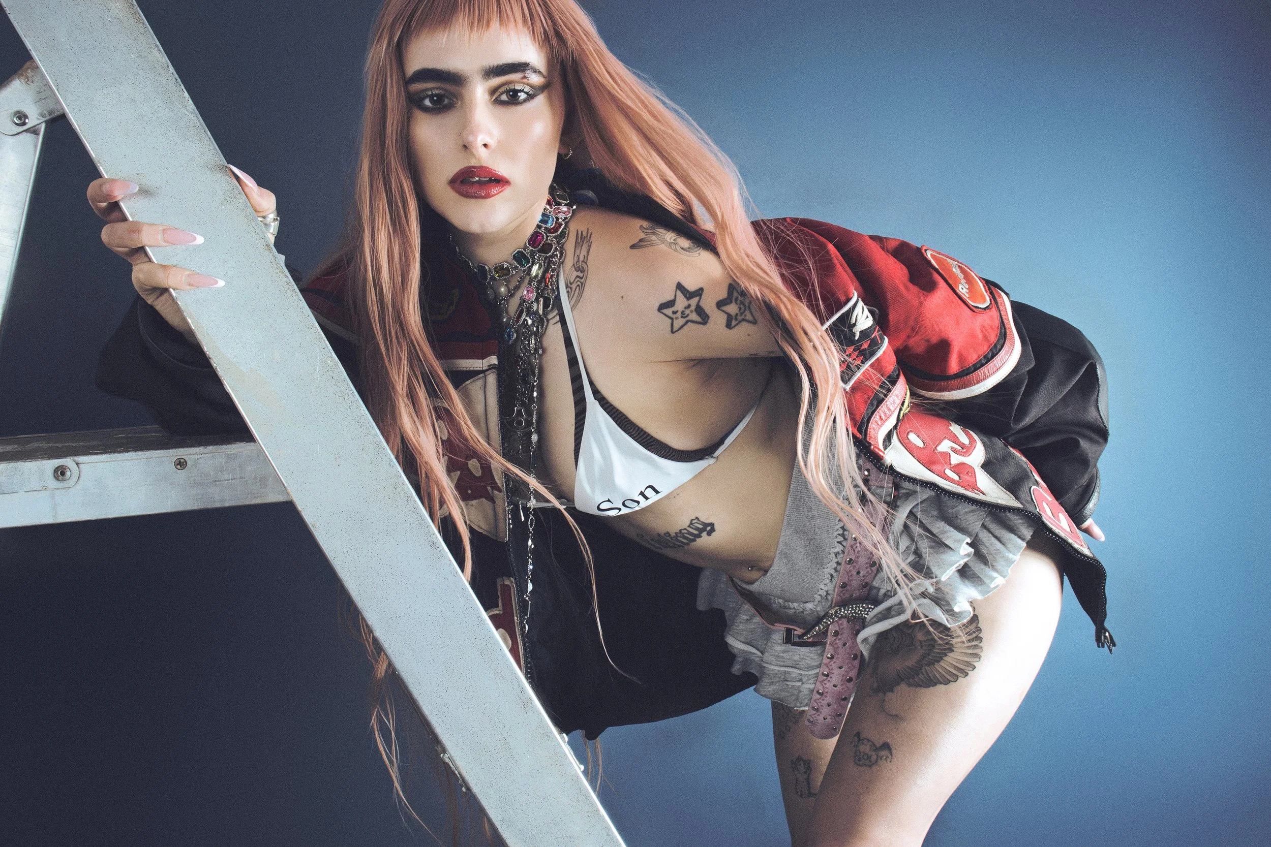  Lozeak wears, Bikini Top: Praying, Skirts: Vintage, Jacket: Vintage Red Bull Racing, Belt: Stylist’s Own, Rings: Rat Betty, Necklace: Era of Mystique, &amp; Archive, Legwarmers: Stella Xingyi, Shoes: Ancuta Sarca  