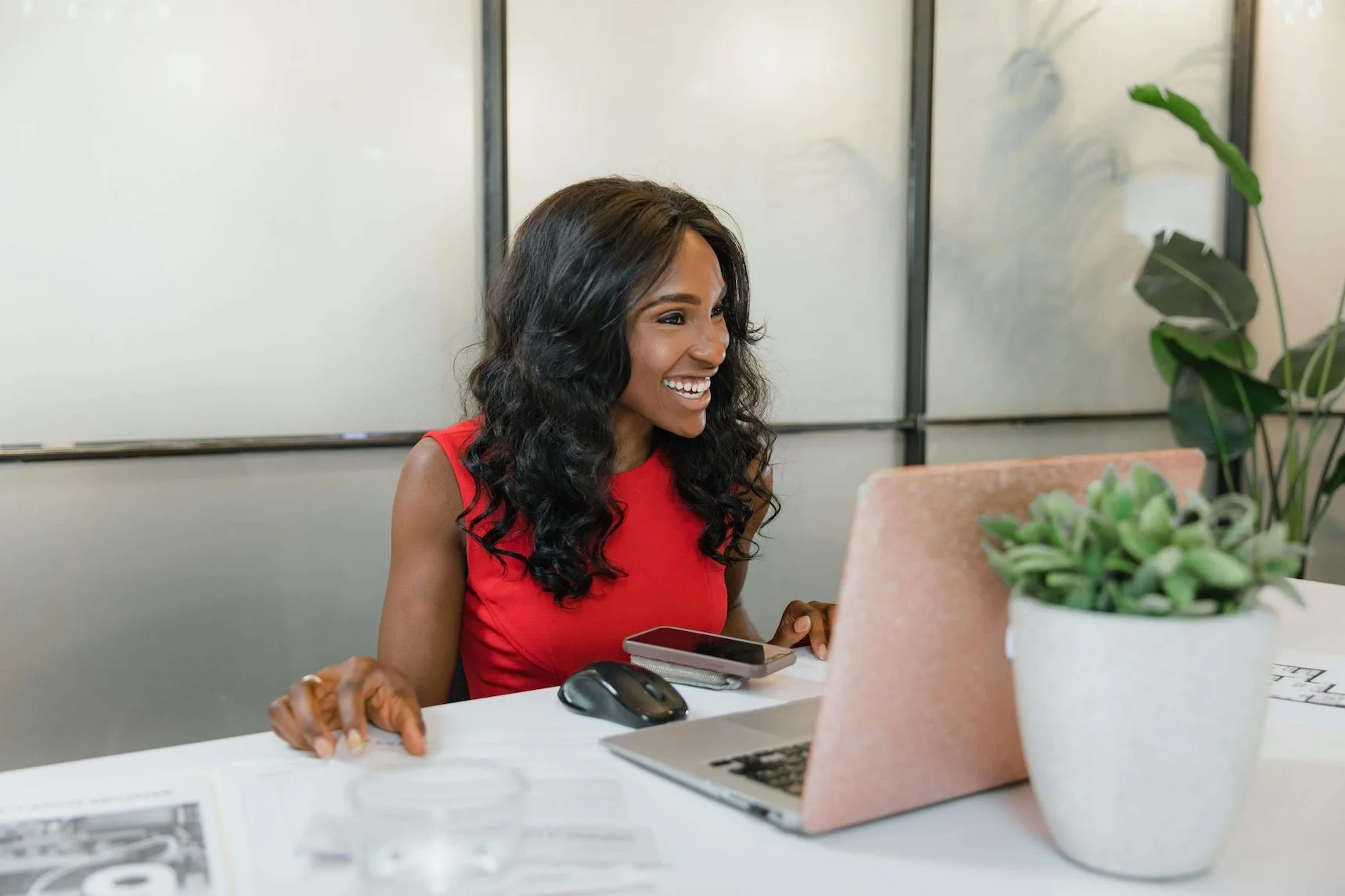 A woman looking at laptop with smile on her face.