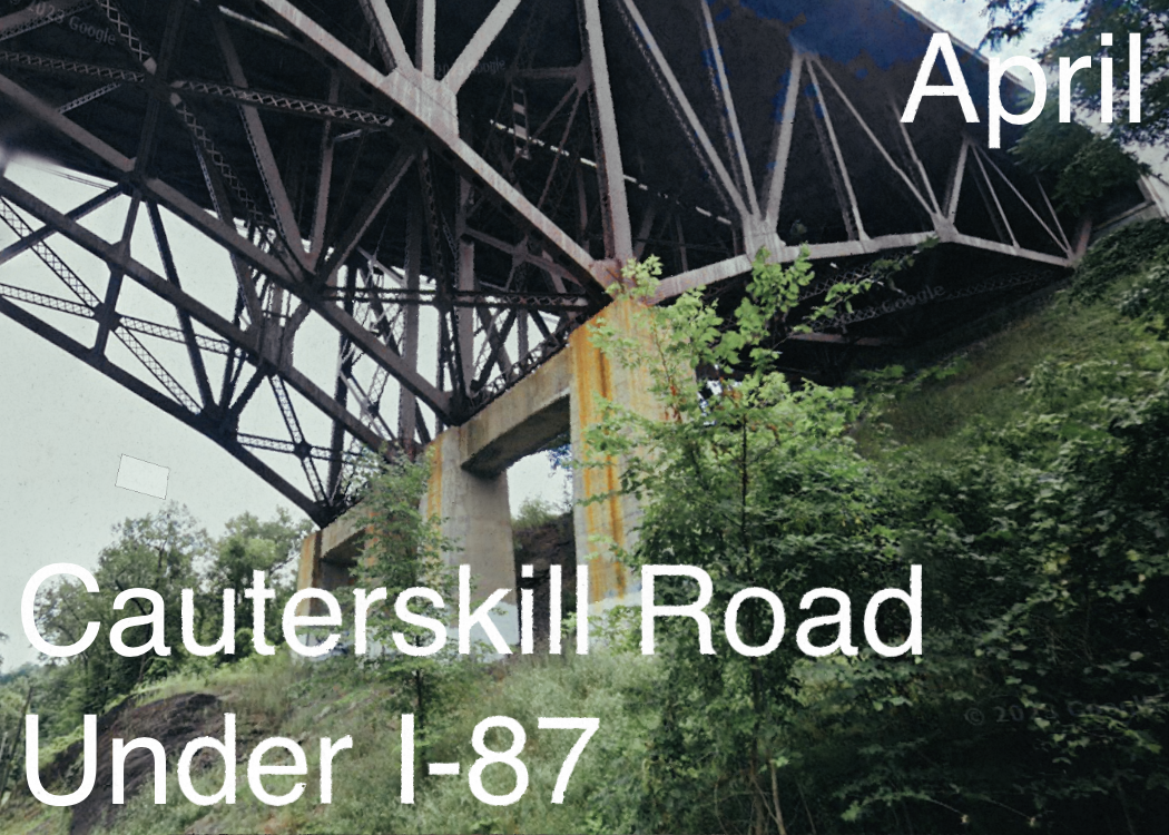 View of a steel bridge support structure over a lush green area with trees, with the text "April" and "Cauterskill Road Under I-87" overlaid.