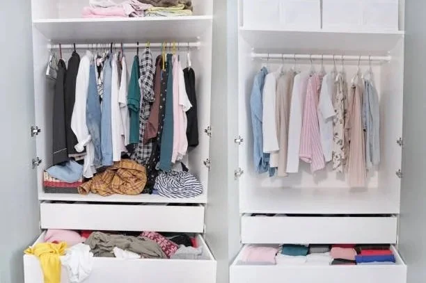 Open white closet with hanging clothes, folded clothes, and accessories