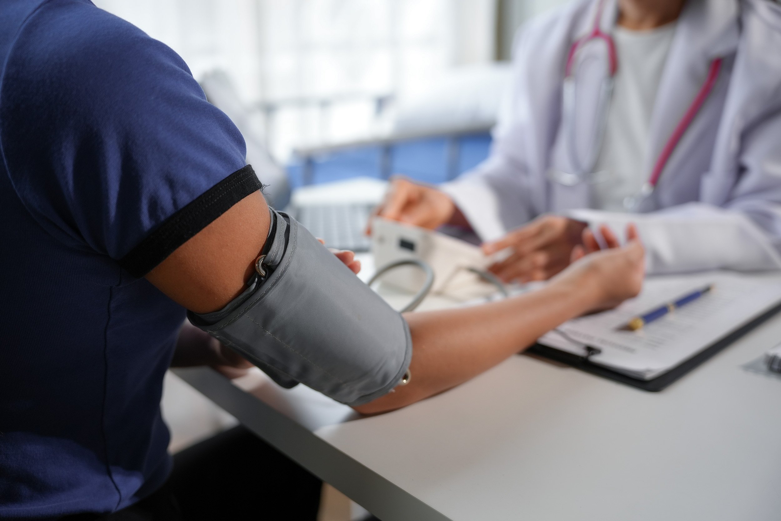 Medical professional checking patient's blood pressure using a cuff.